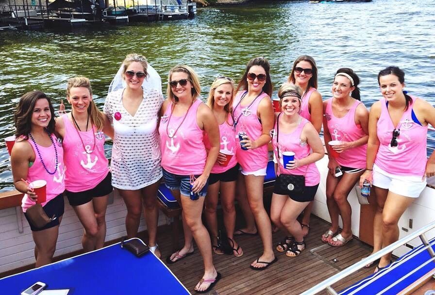 bachelorette party posing on water taxi bride in the middle