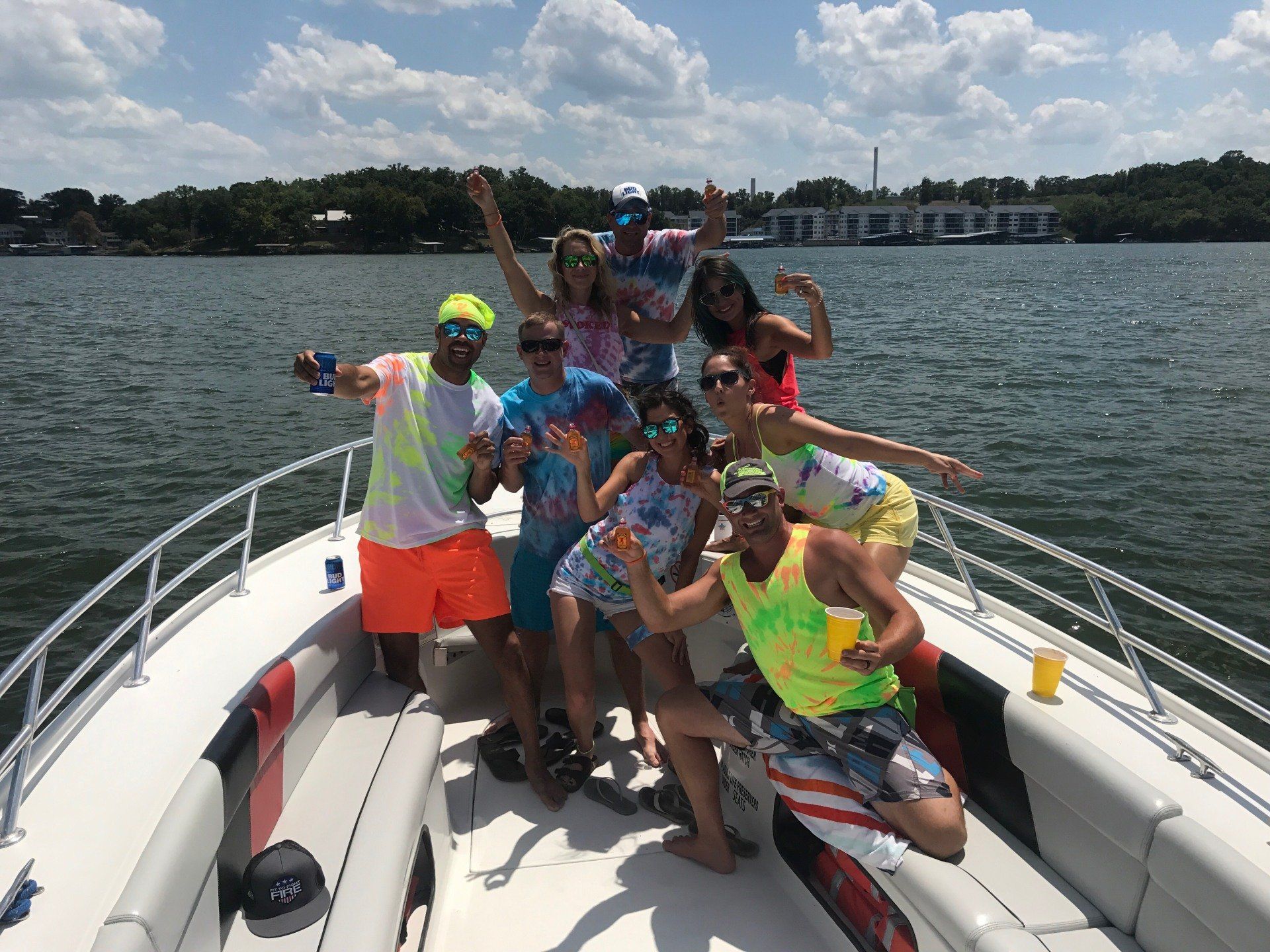 group wearing tie dye posing on water taxi with Fireball shots