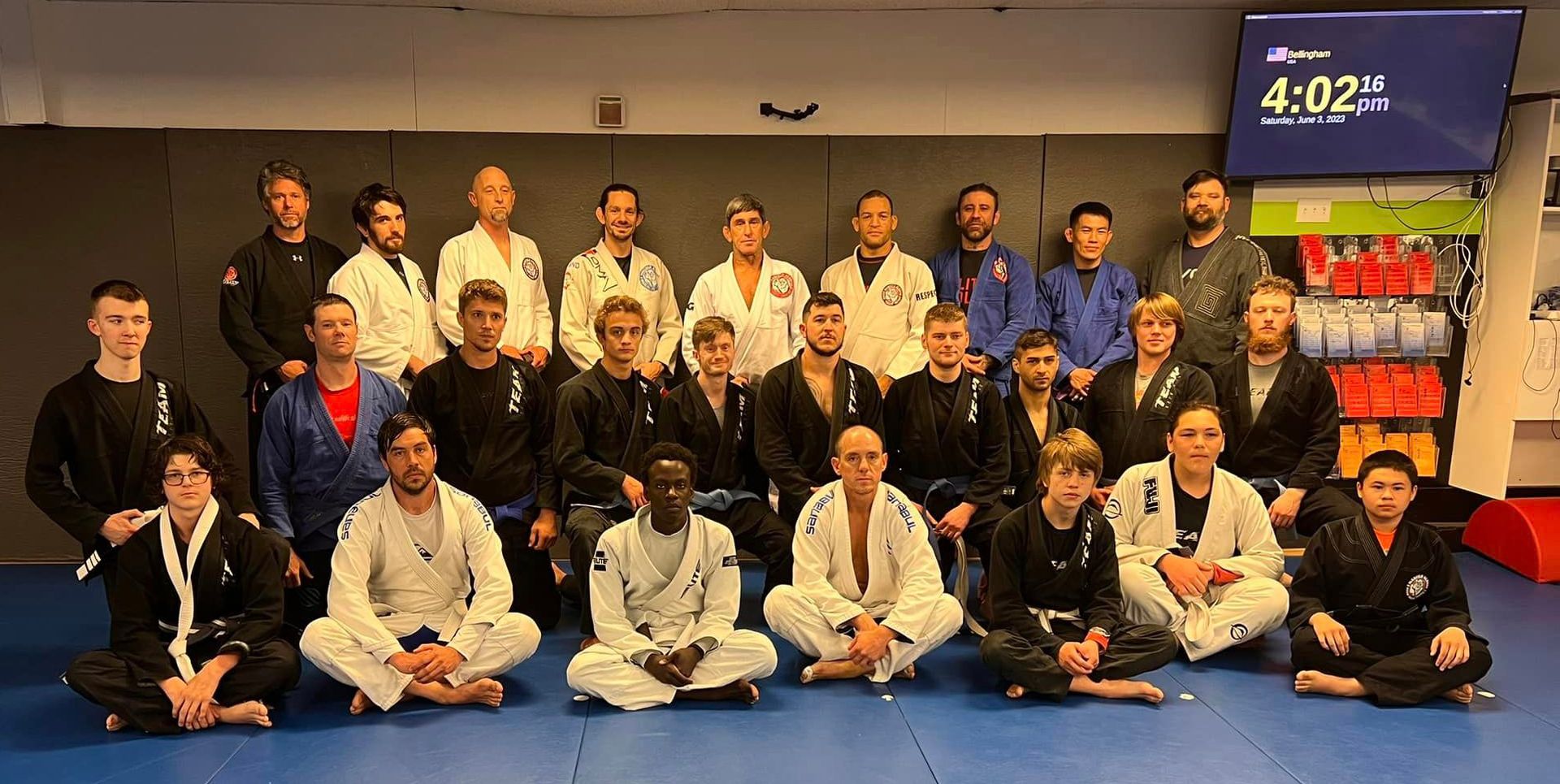 group of mixed martial arts students posing together in the gym