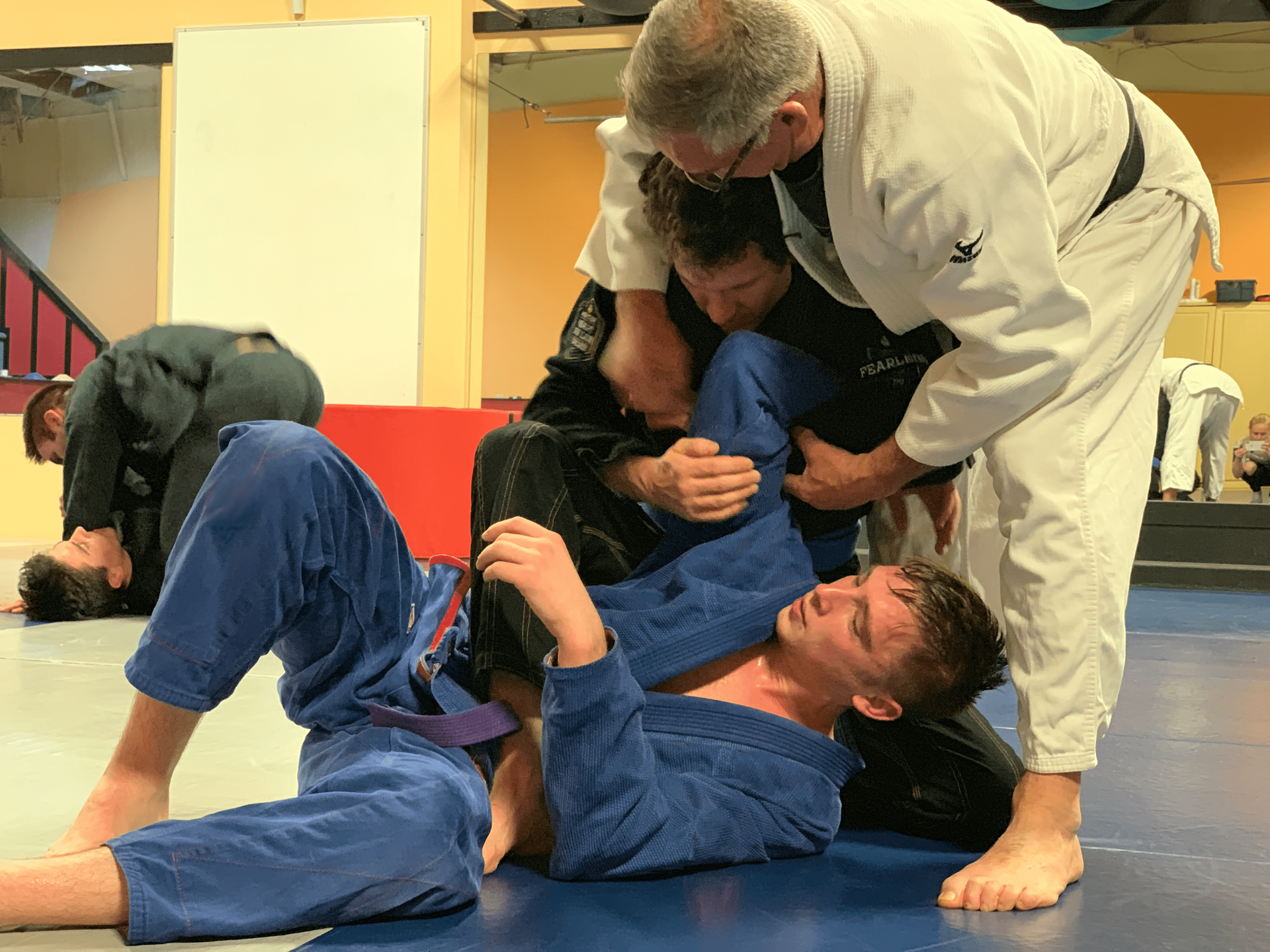 A group of men are practicing jiu jitsu in a gym.