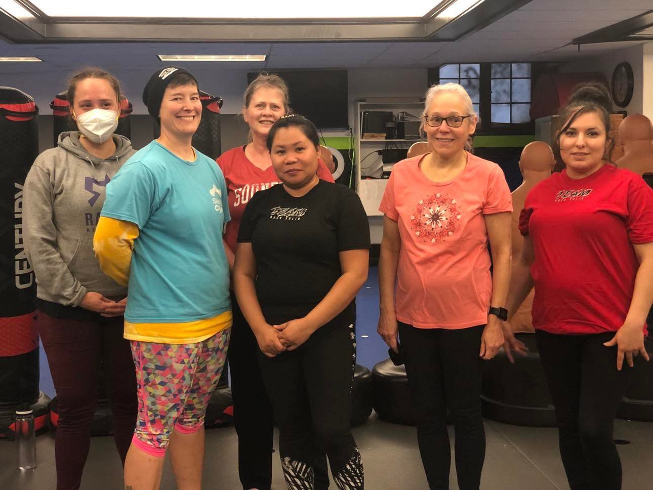 A group of women are posing for a picture in a gym.