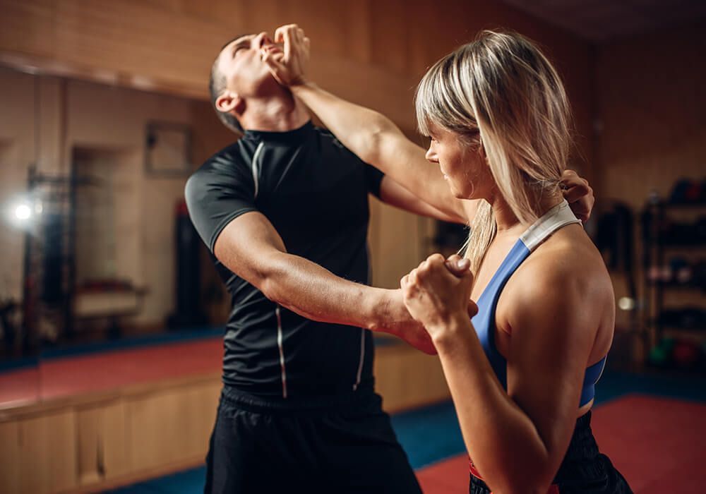 female student practicing a self-defense technique with a partner in class