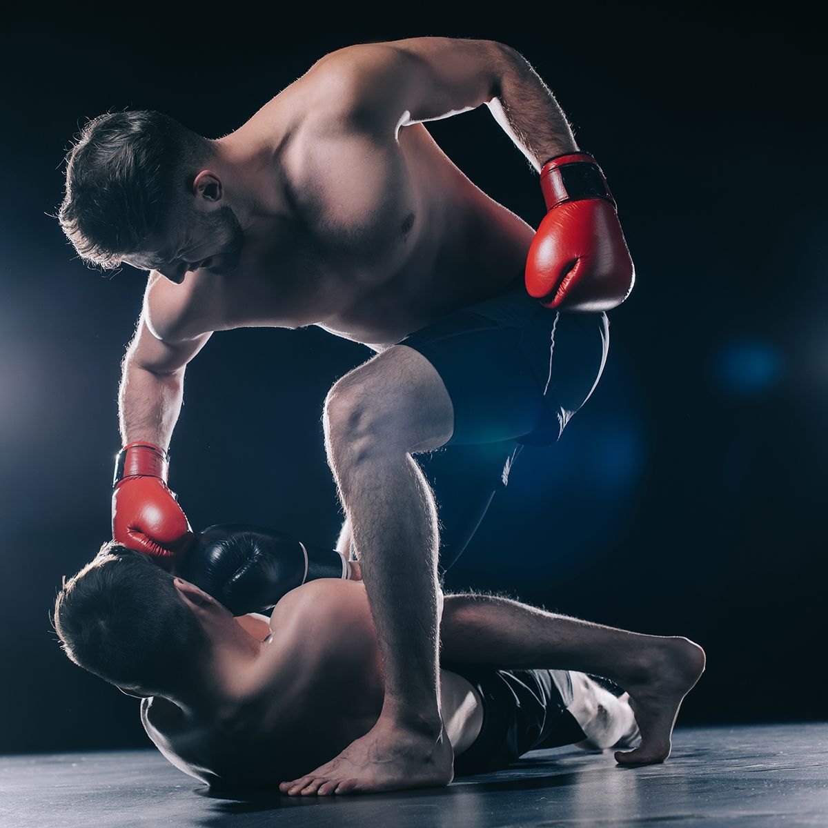 Two men in boxing gloves are fighting in a ring