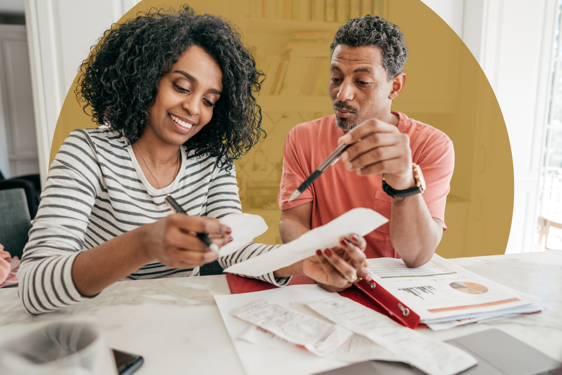 A man and a woman are sitting at a table looking at papers.