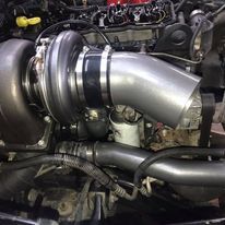 A close up of a turbocharger on a car engine.