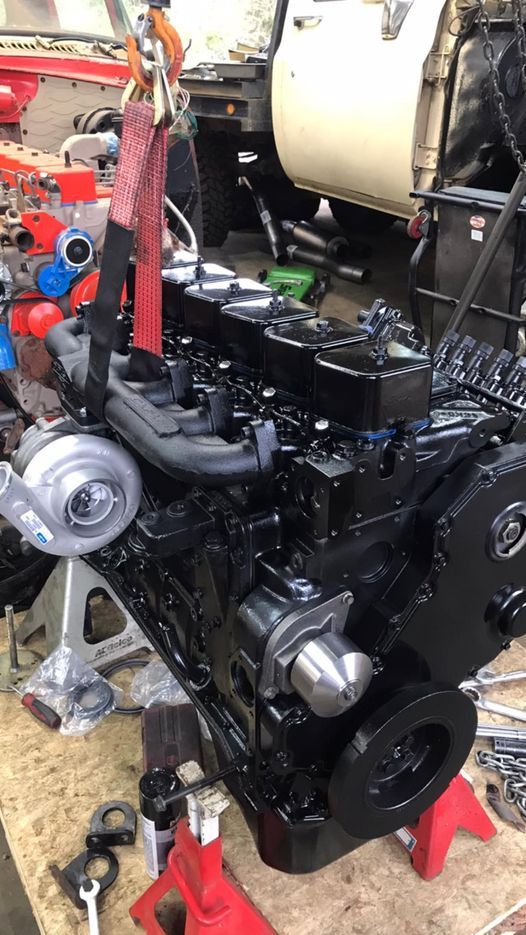 A black engine is sitting on top of a wooden table.