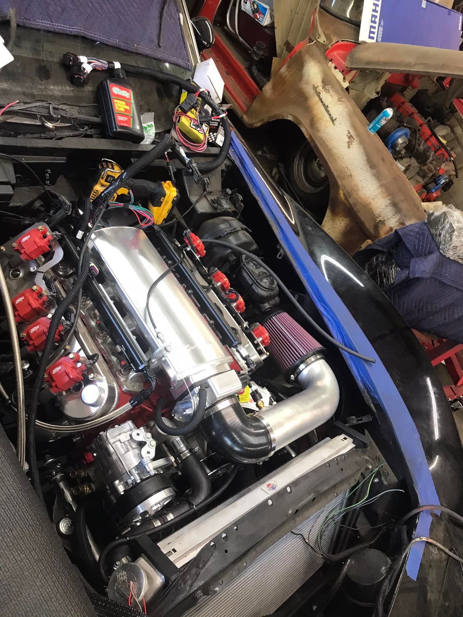 A car engine is being worked on in a garage.