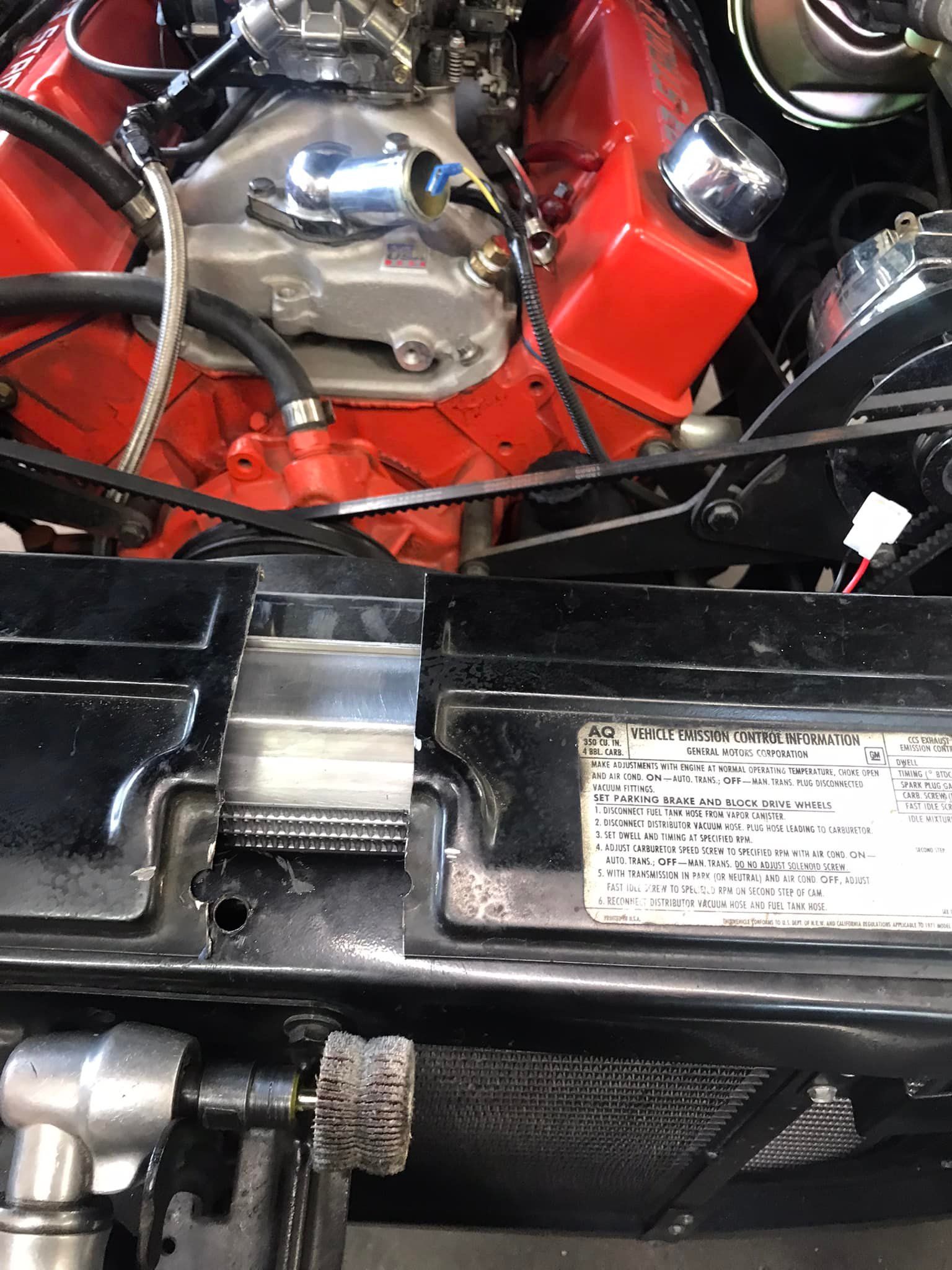 A close up of a red engine under the hood of a car.