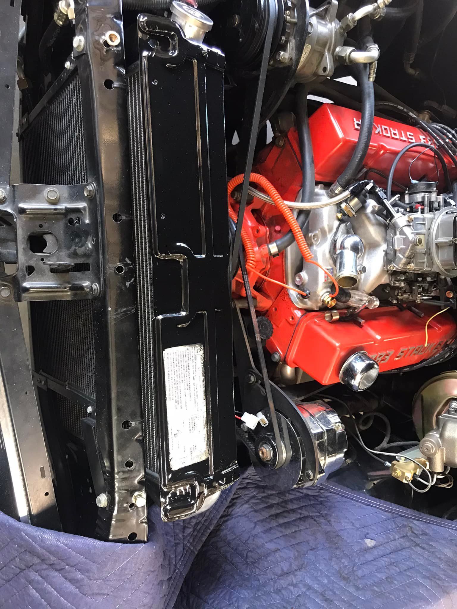 A red engine is sitting inside of a black car.