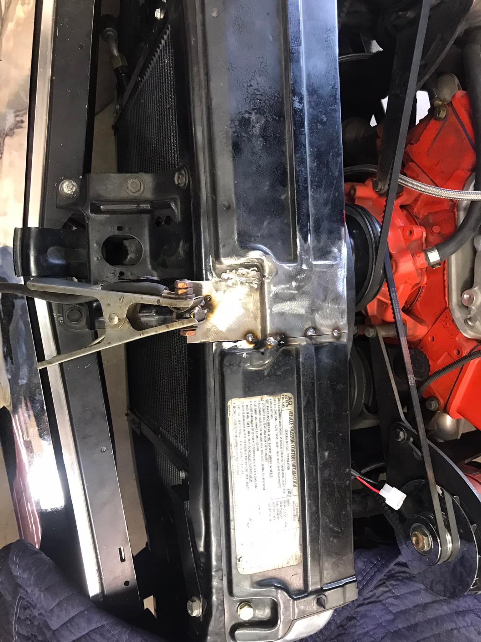 A close up of a radiator on a car with a red engine.