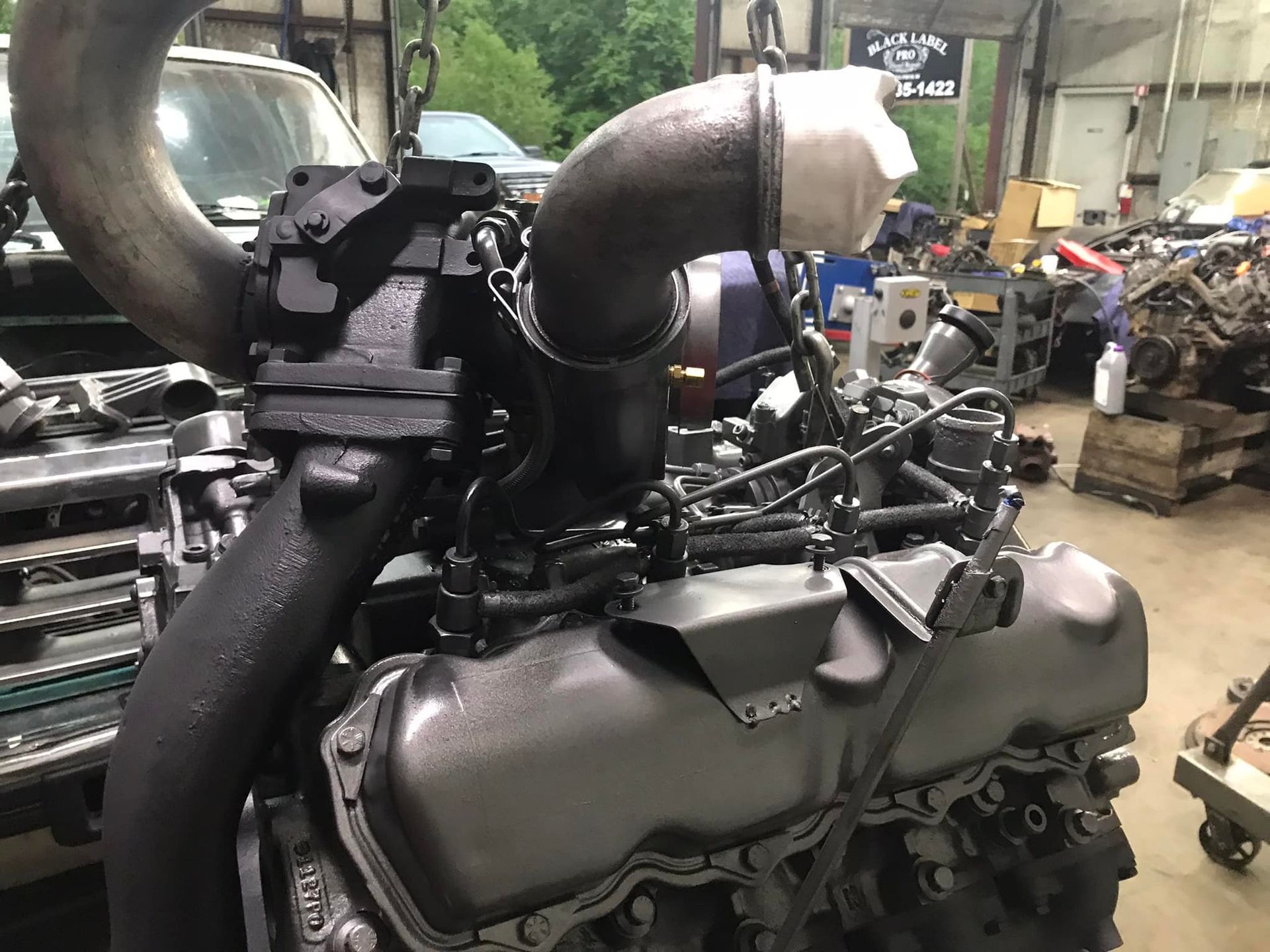 A large black engine is sitting in a garage.