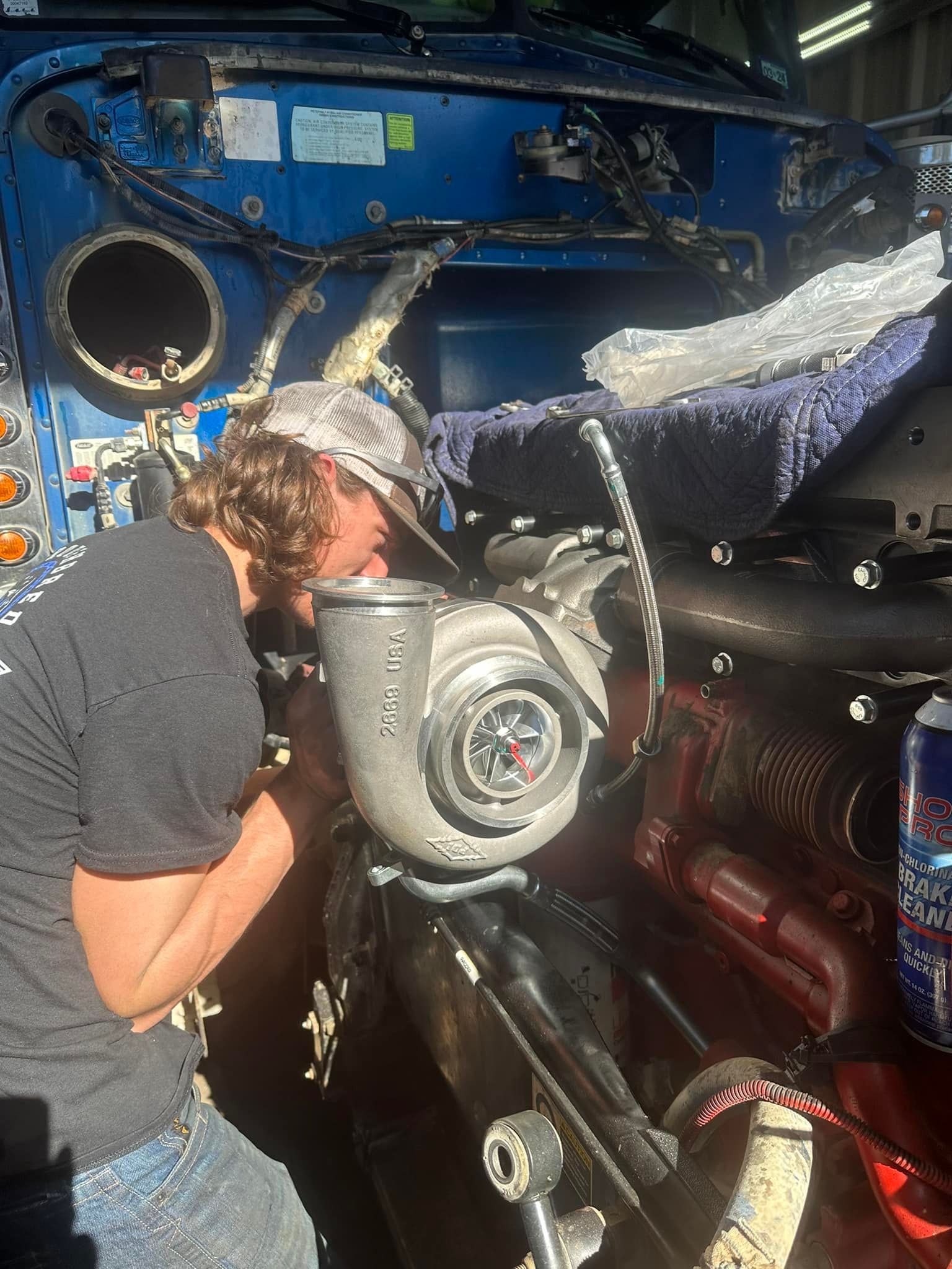 A man is working on a turbocharger on a car.