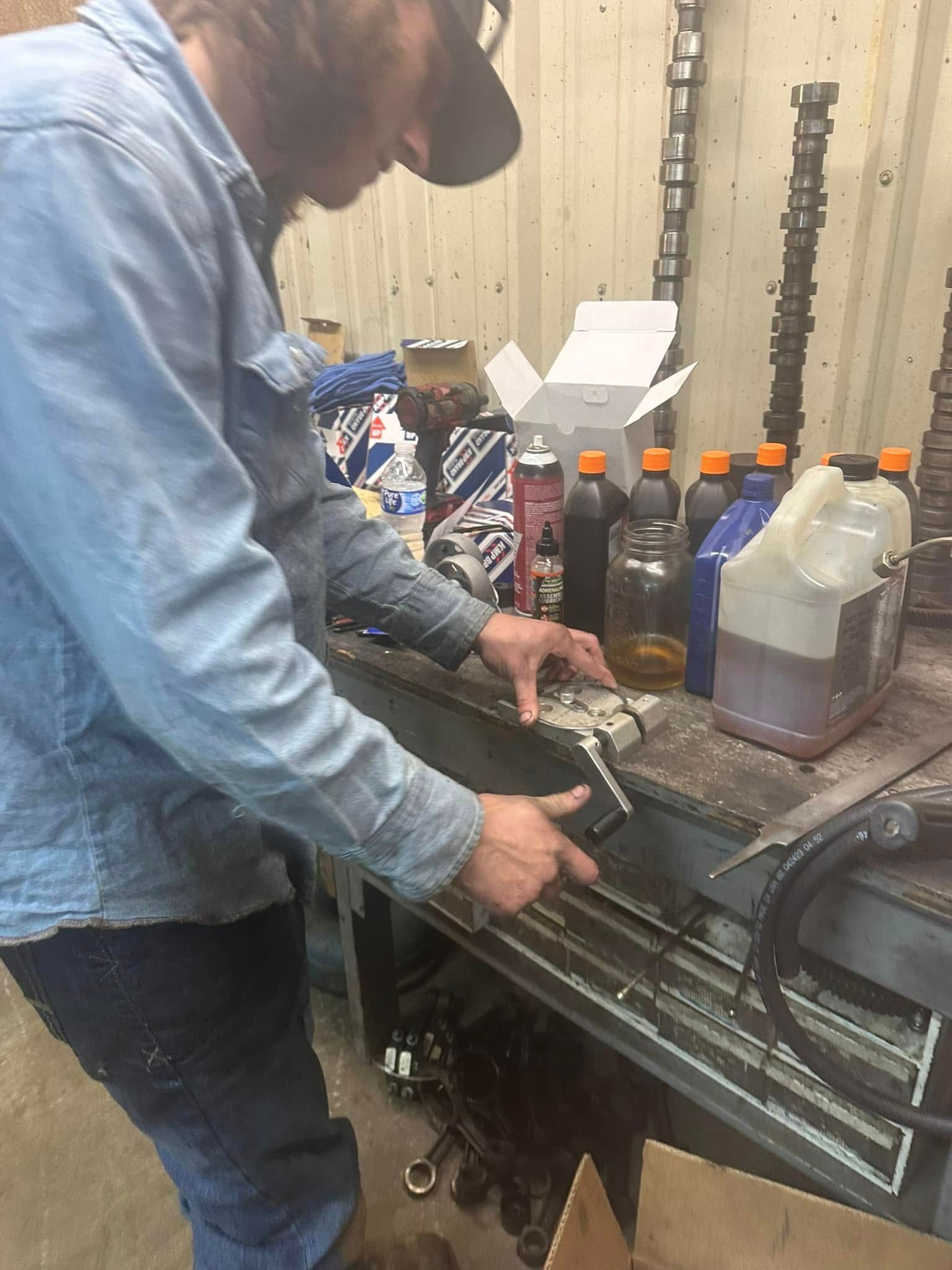 A man is working on a car engine in a garage.