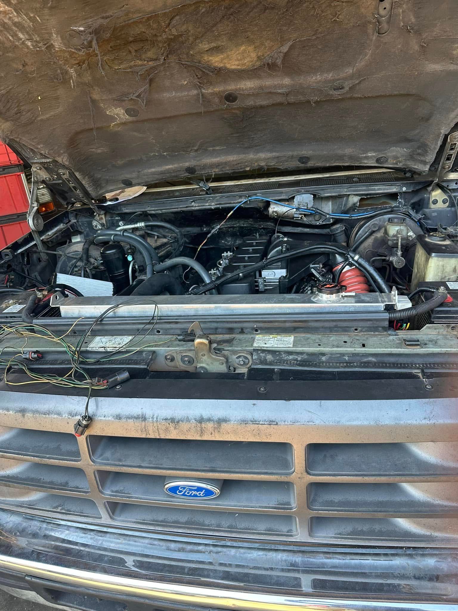 The hood of a truck is open and the engine is visible.