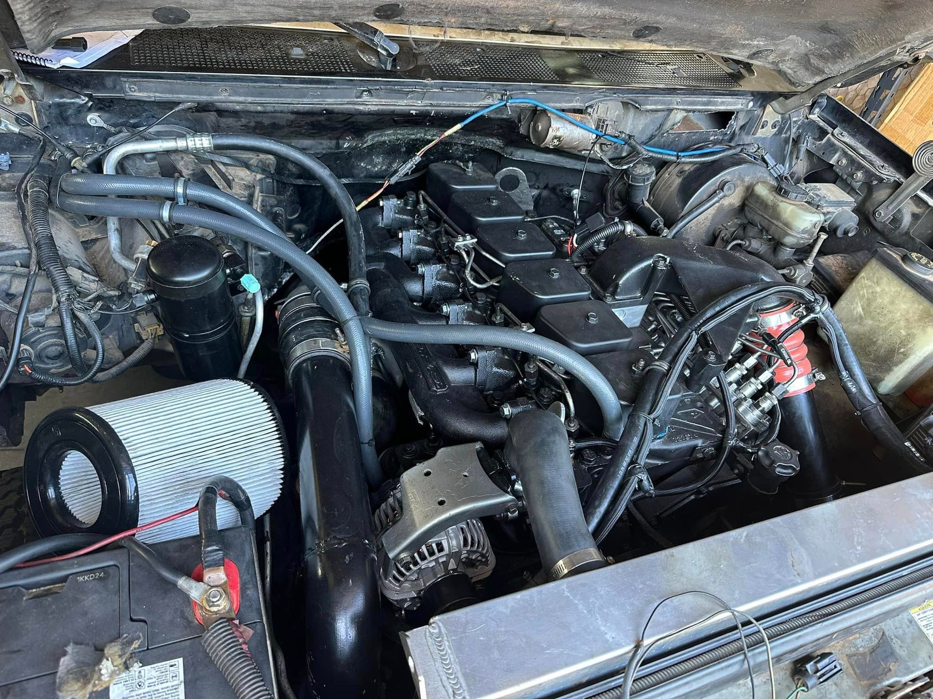 A close up of a car engine with the hood open