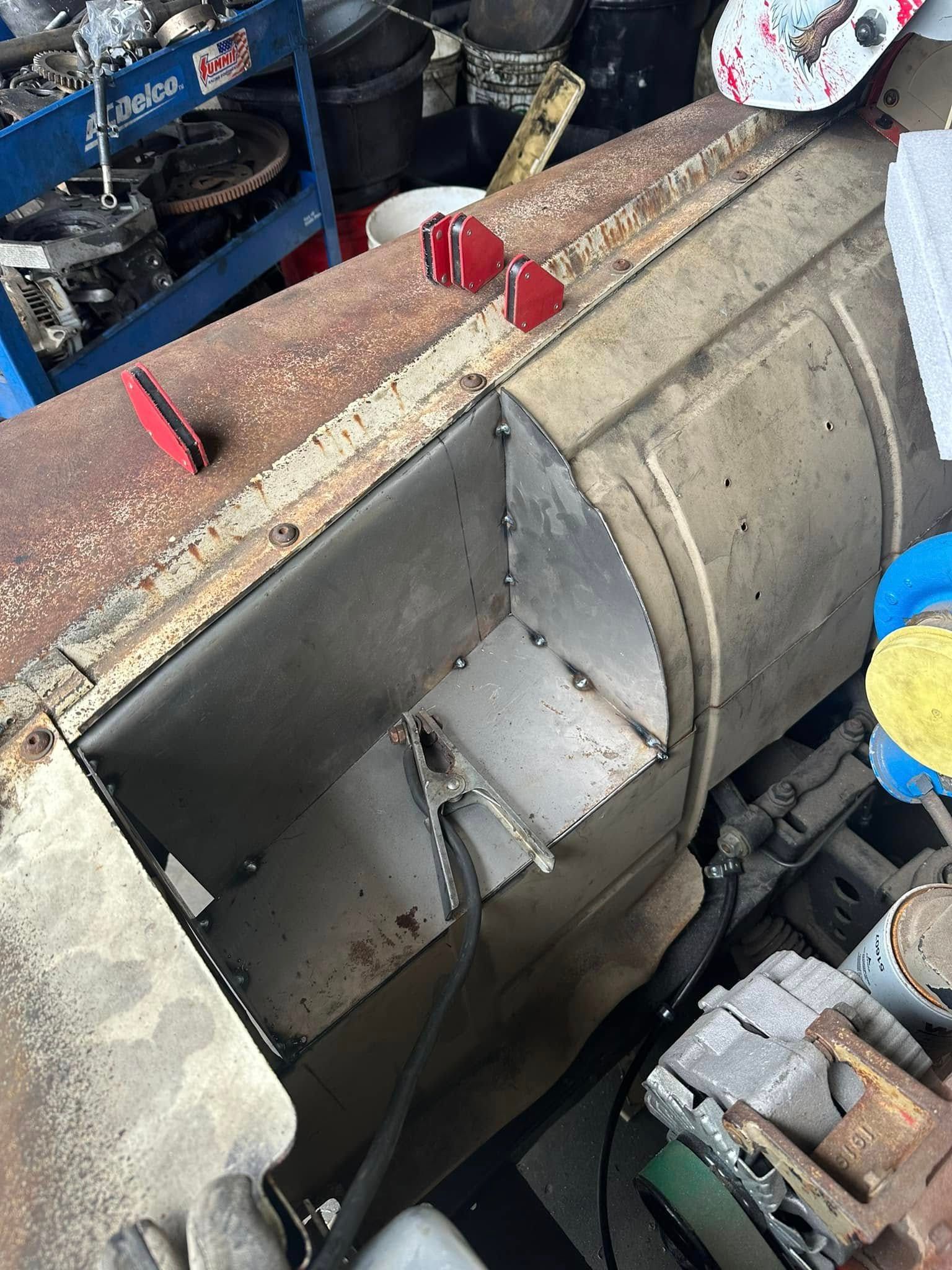 A pile of junk is sitting on top of a table in a garage.