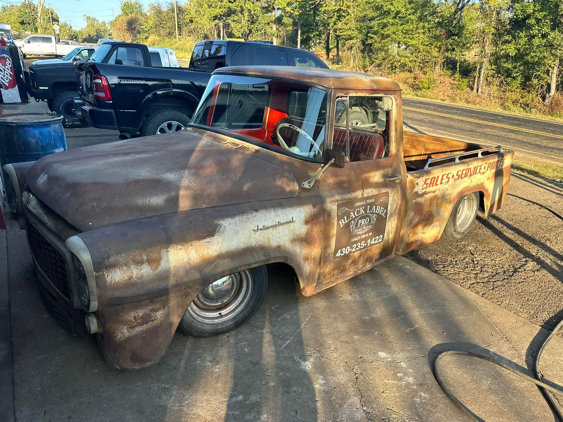 An old rusty truck is parked on the side of the road.