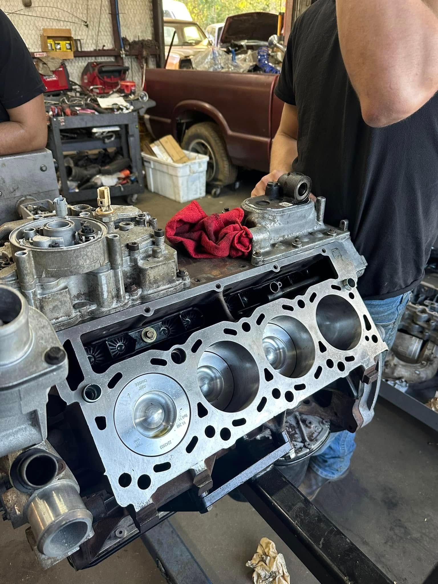 A man is working on a car engine in a garage.