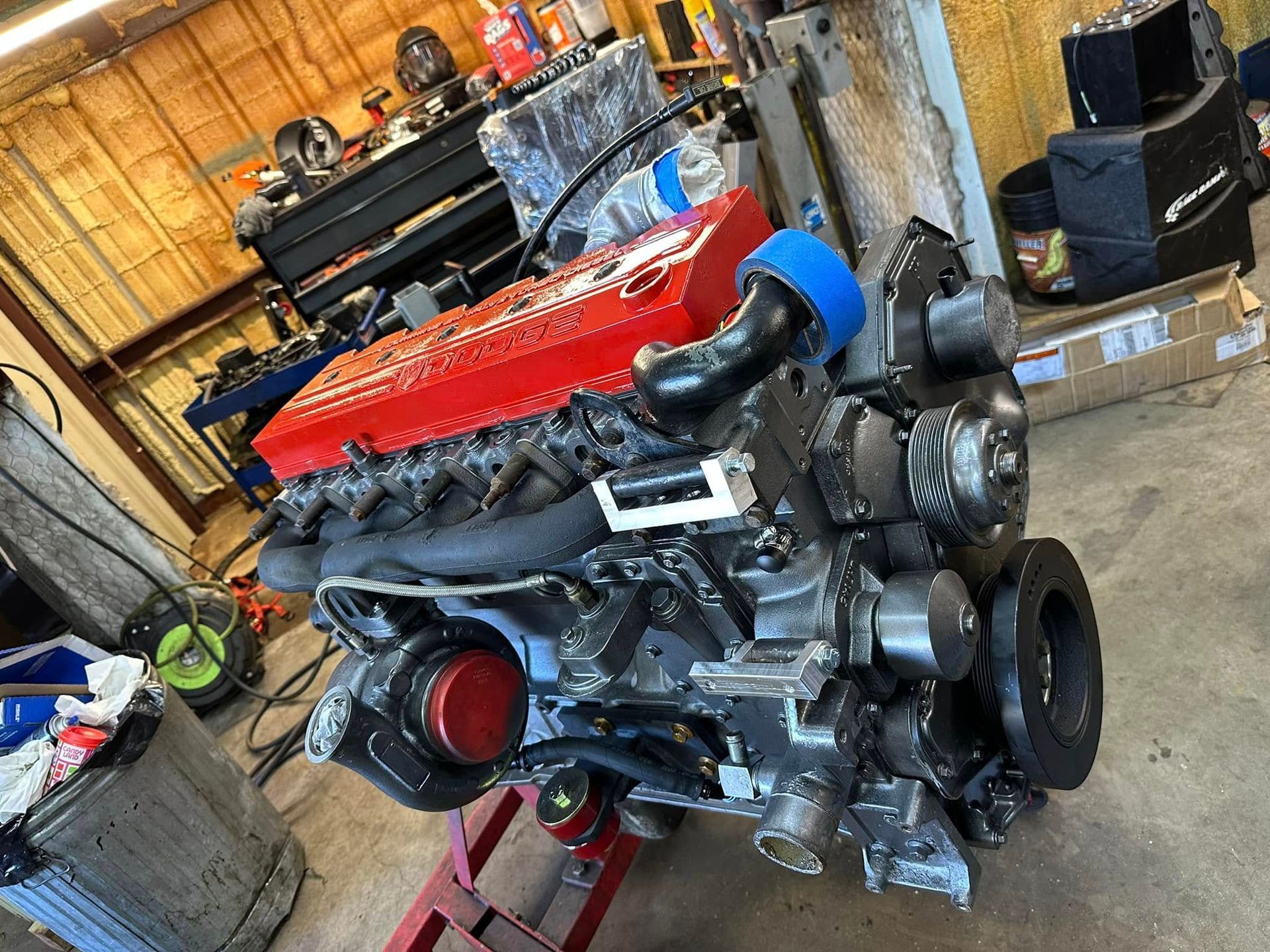 A large engine is sitting on top of a concrete floor in a garage.