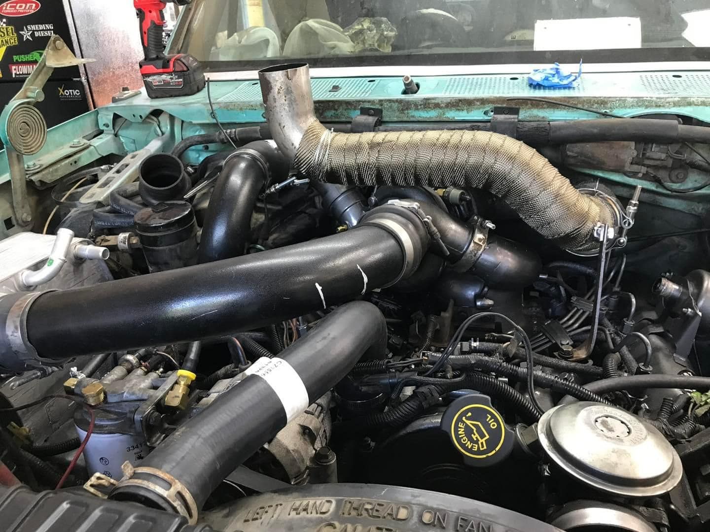 The engine of a car is being worked on in a garage.