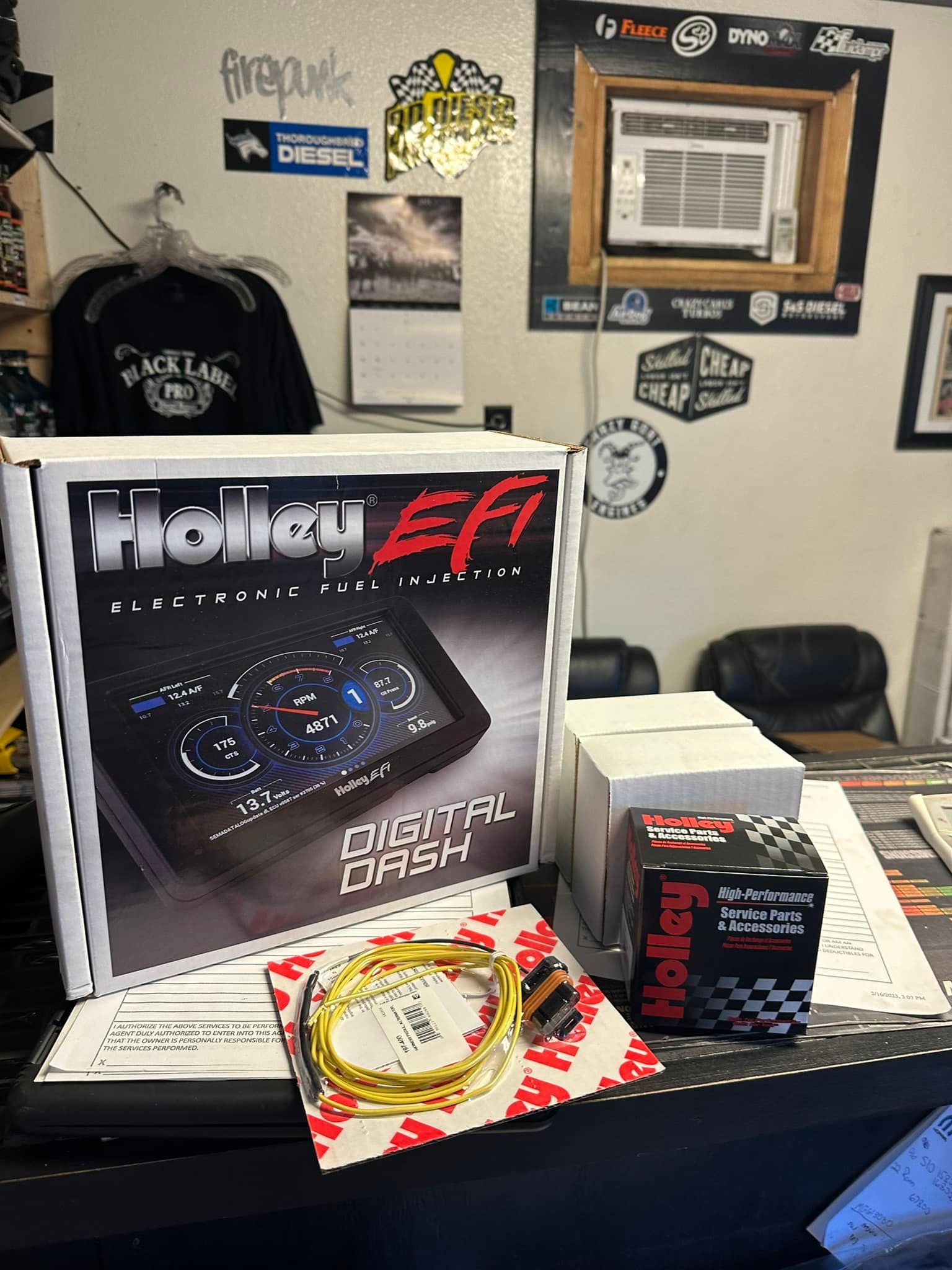 A holley digital dash is sitting on a table in a store.