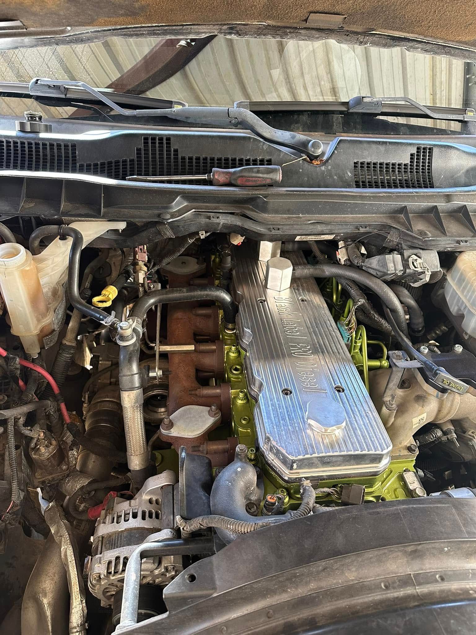 A close up of a car engine with the hood open.