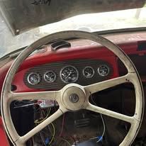 A close up of a steering wheel in a red car.