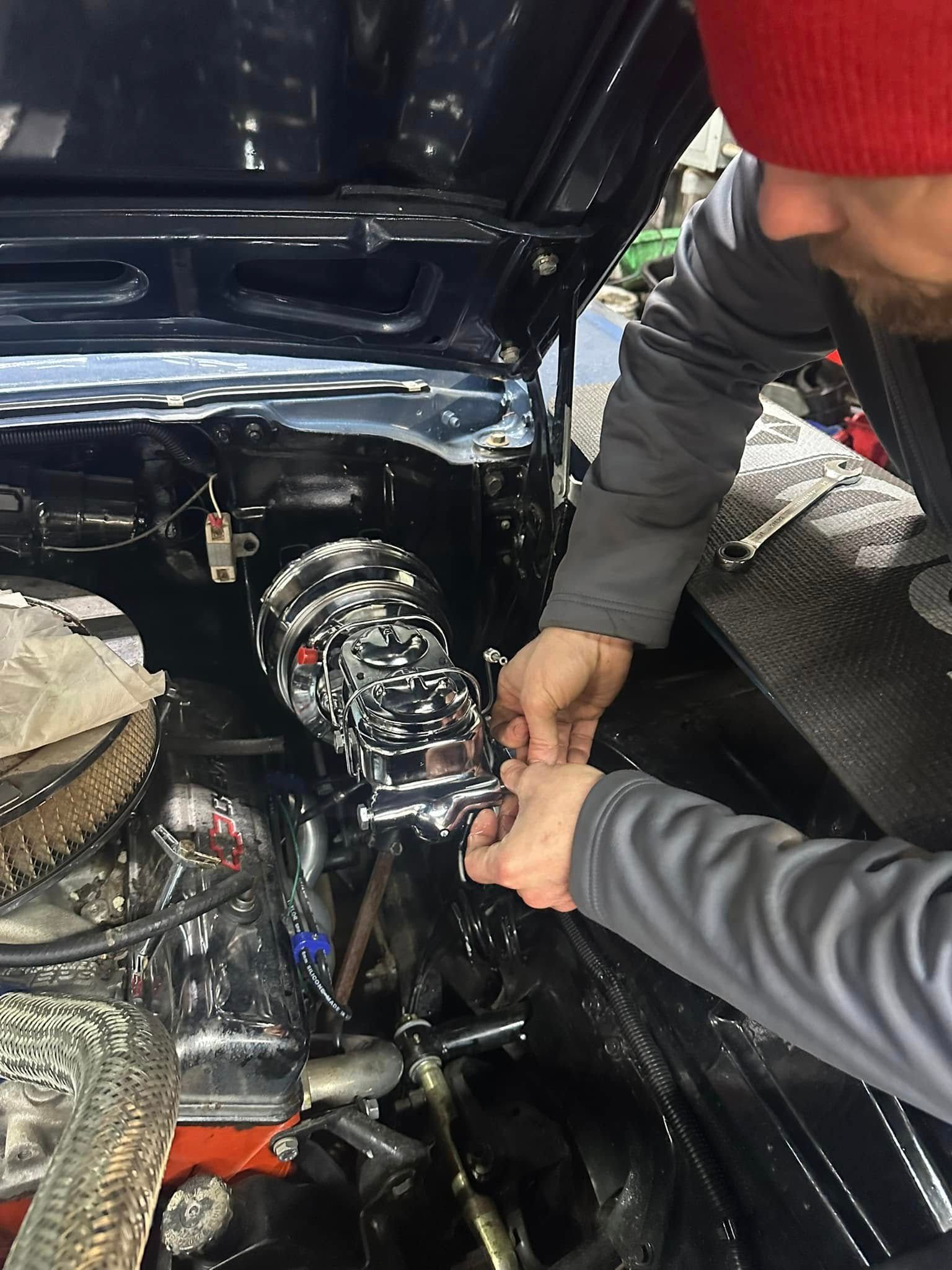 A man is working on the engine of a car.
