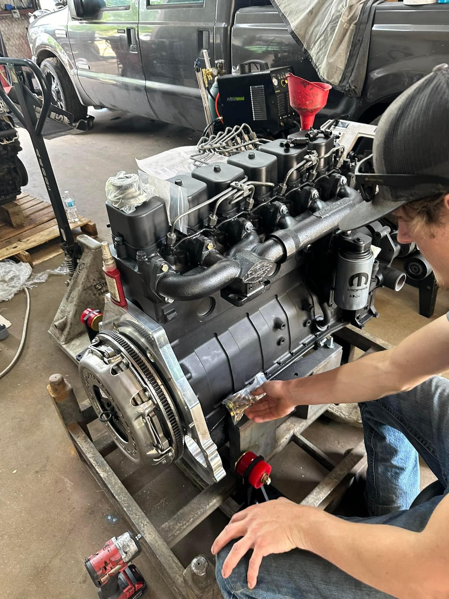 A man is working on a large engine in a garage.