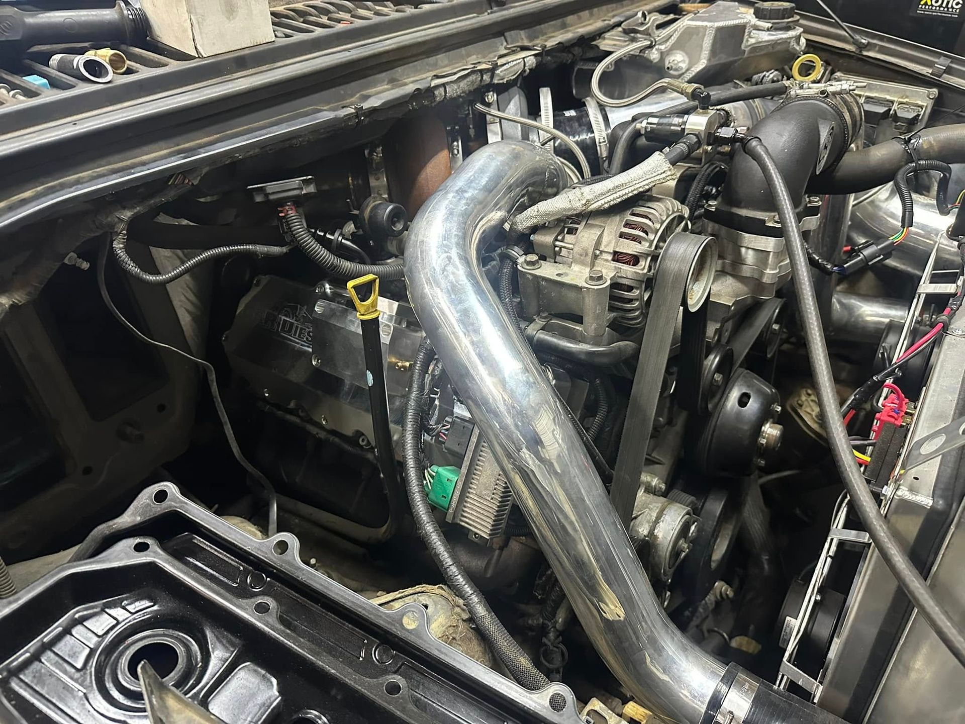 A close up of a car engine with the hood open