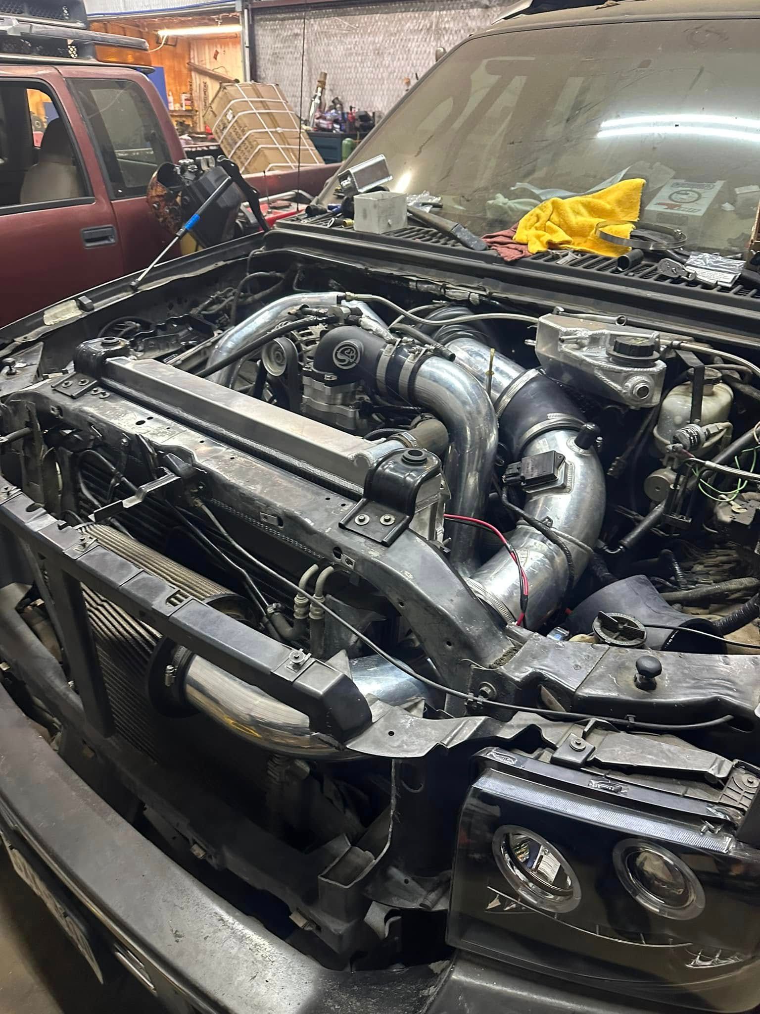 The engine of a car is being worked on in a garage.