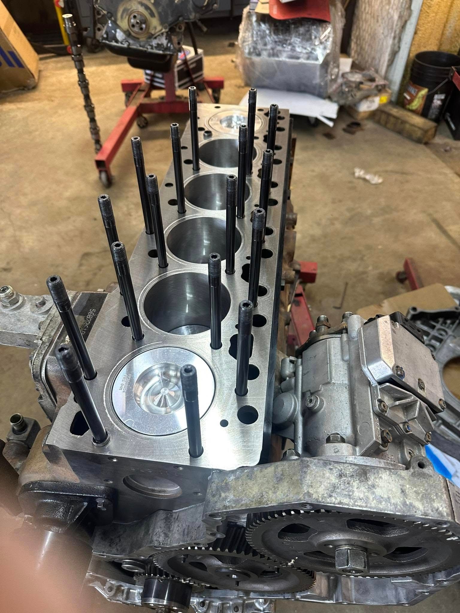 A close up of a metal engine block in a garage.