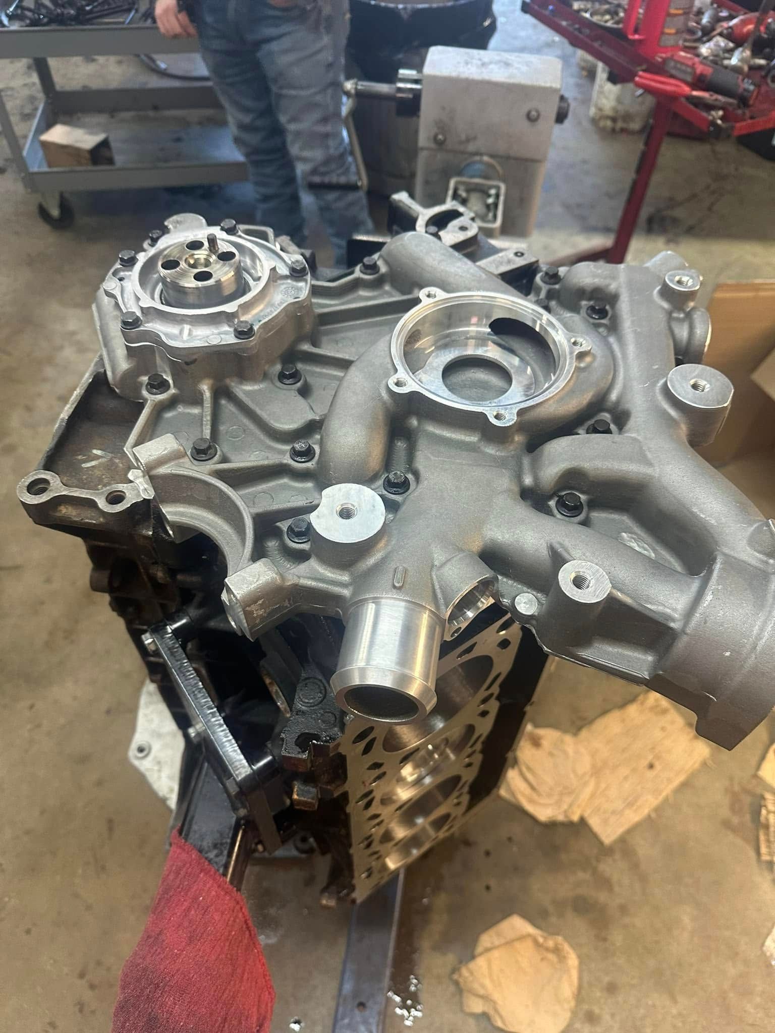 A man is working on a car engine in a garage.