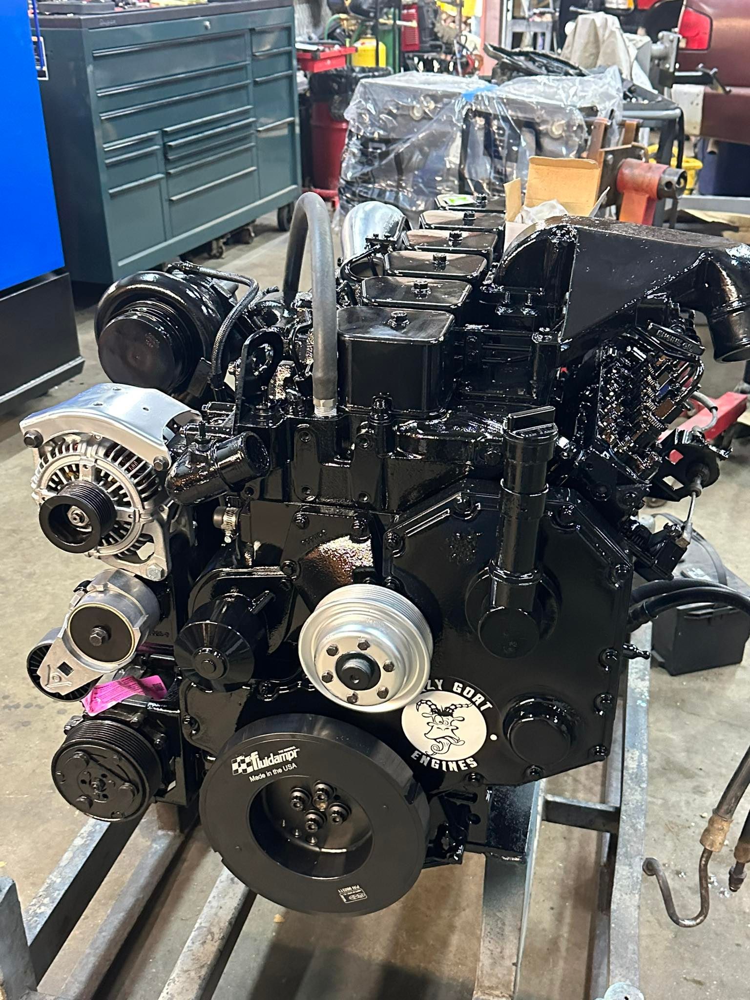 A black engine is sitting on a rack in a garage.