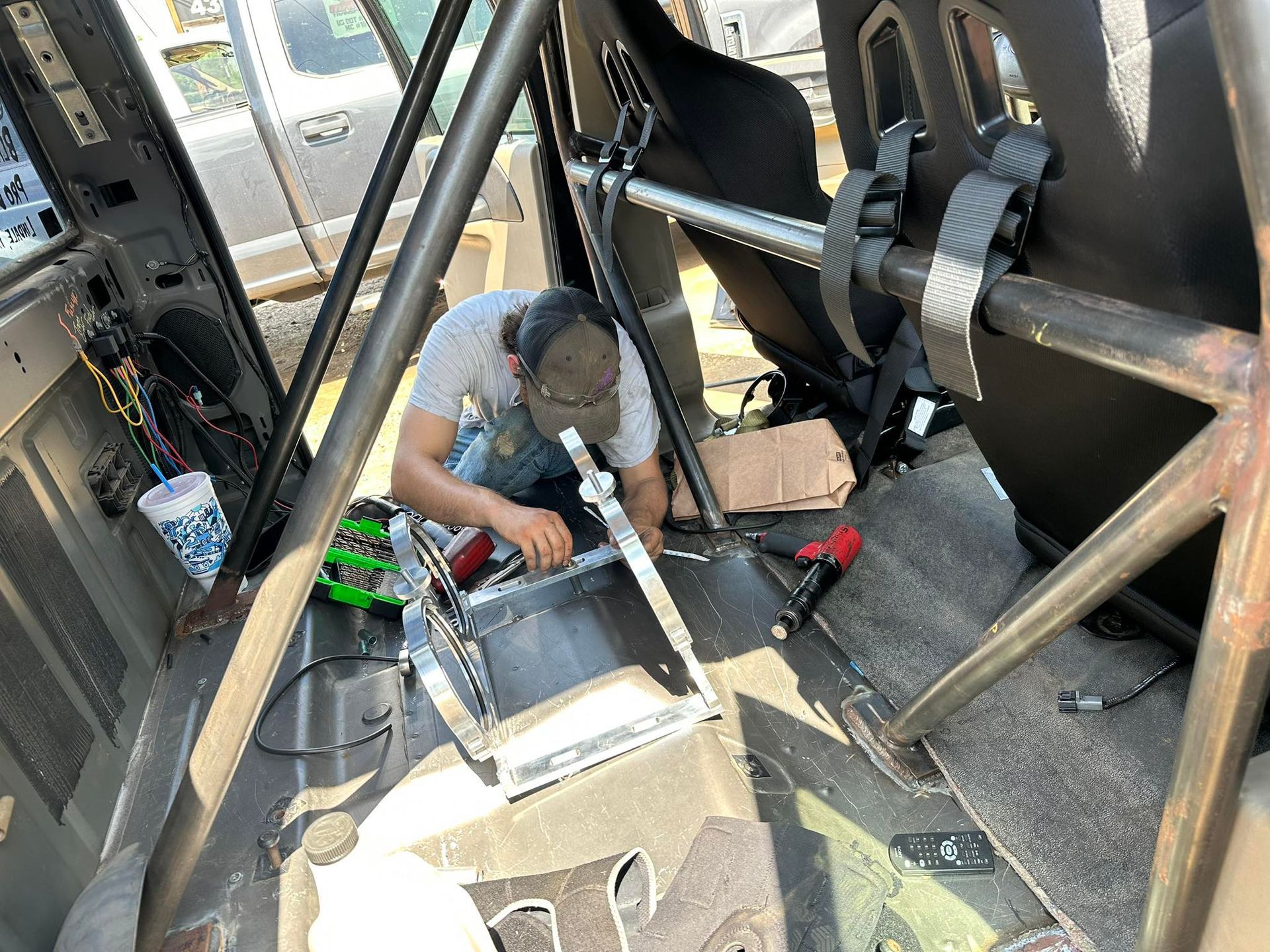 A man is working on the inside of a race car.