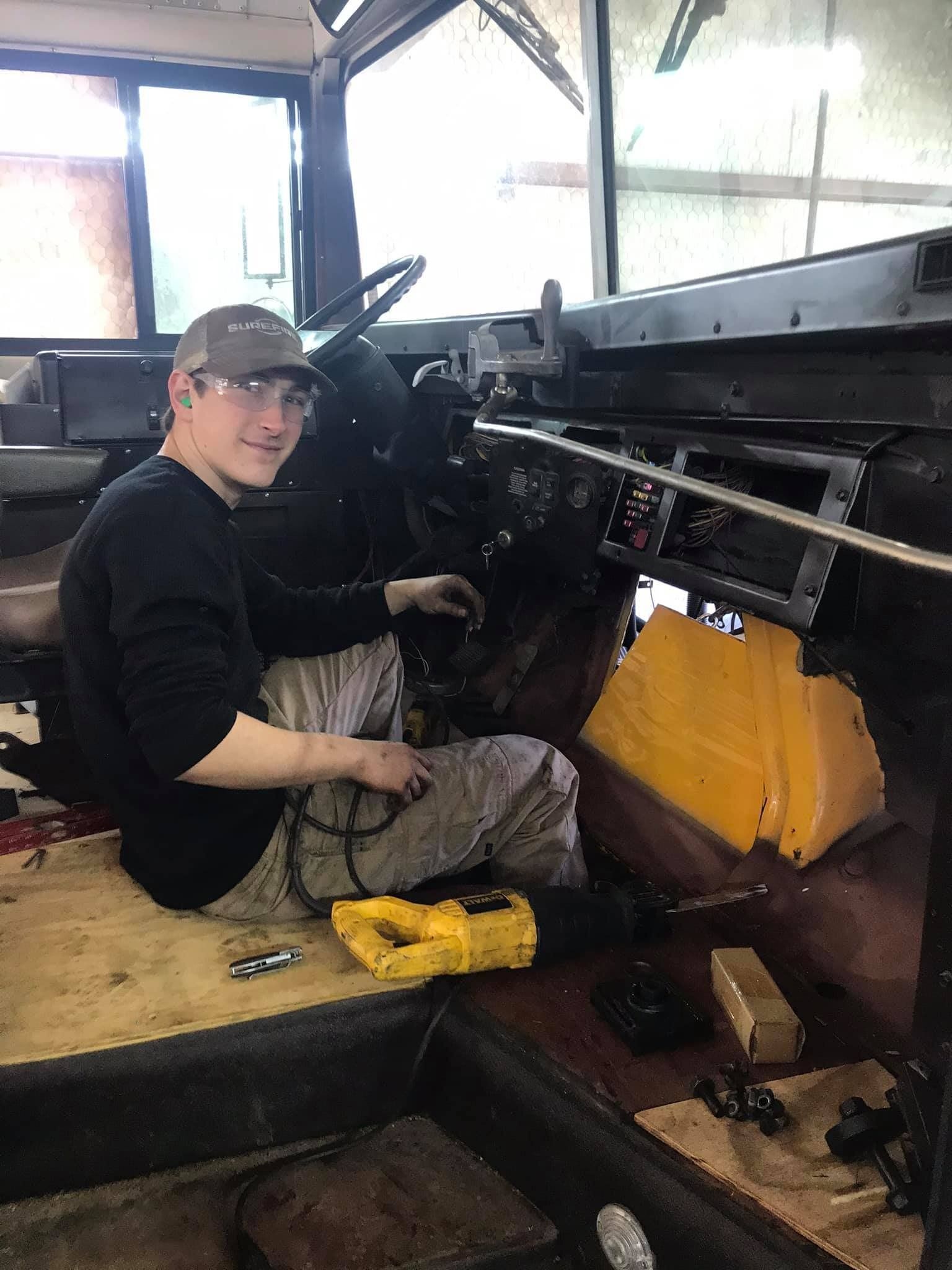 A man is sitting in the driver 's seat of a truck.