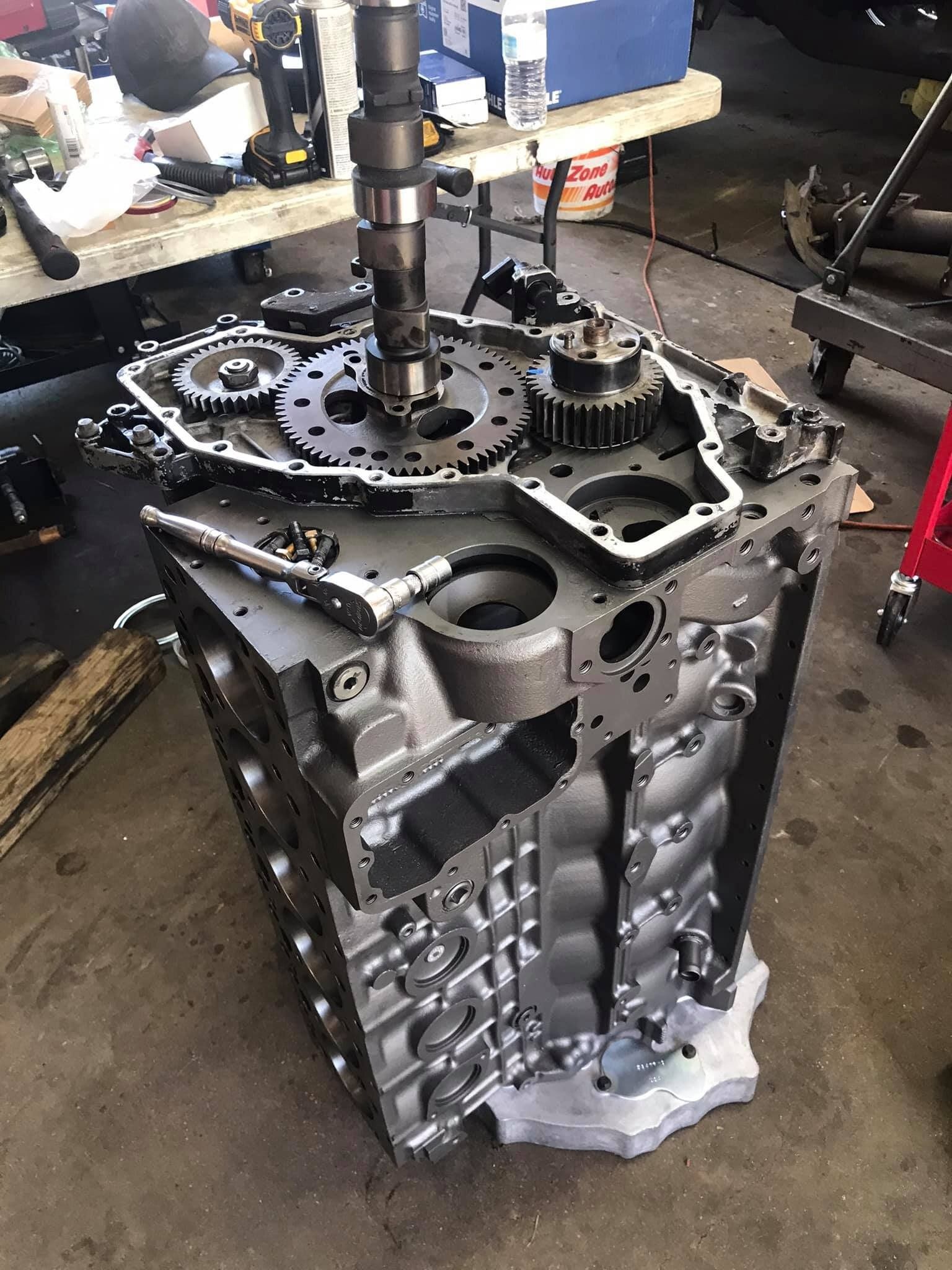 A large engine block is sitting on top of a table in a garage.