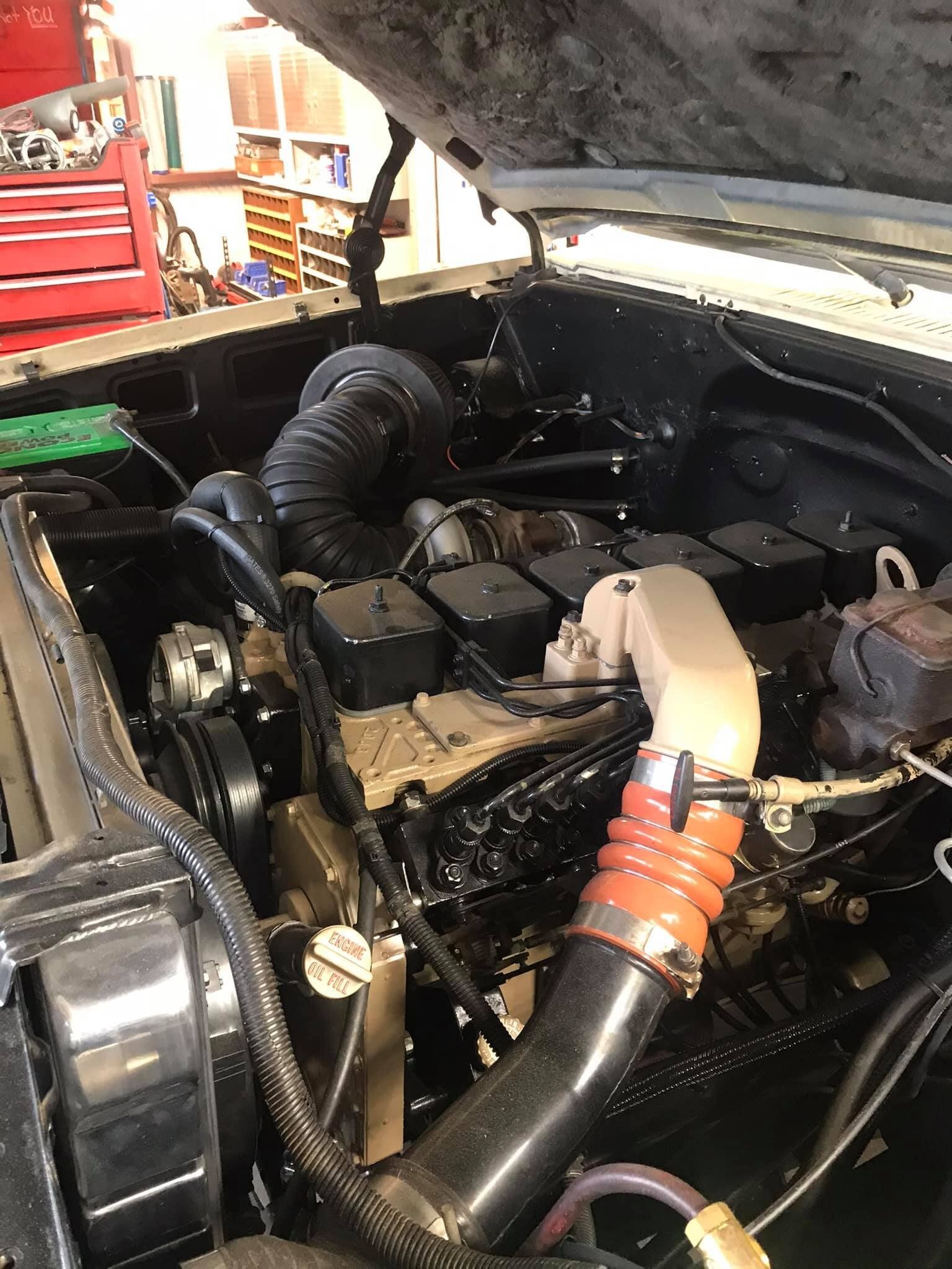 A close up of a car engine with the hood open.