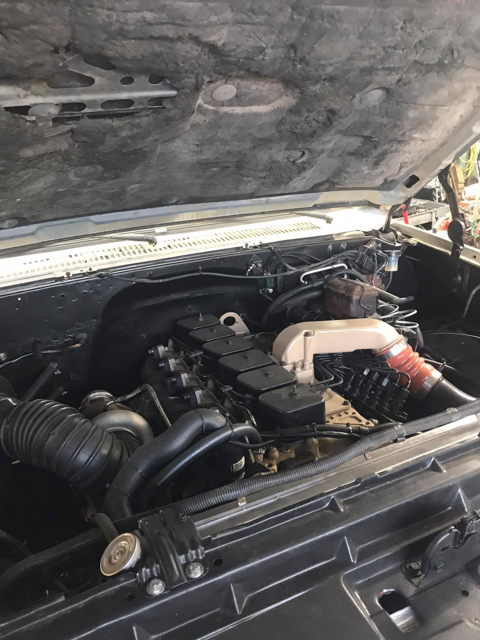 A close up of a car engine with the hood open.