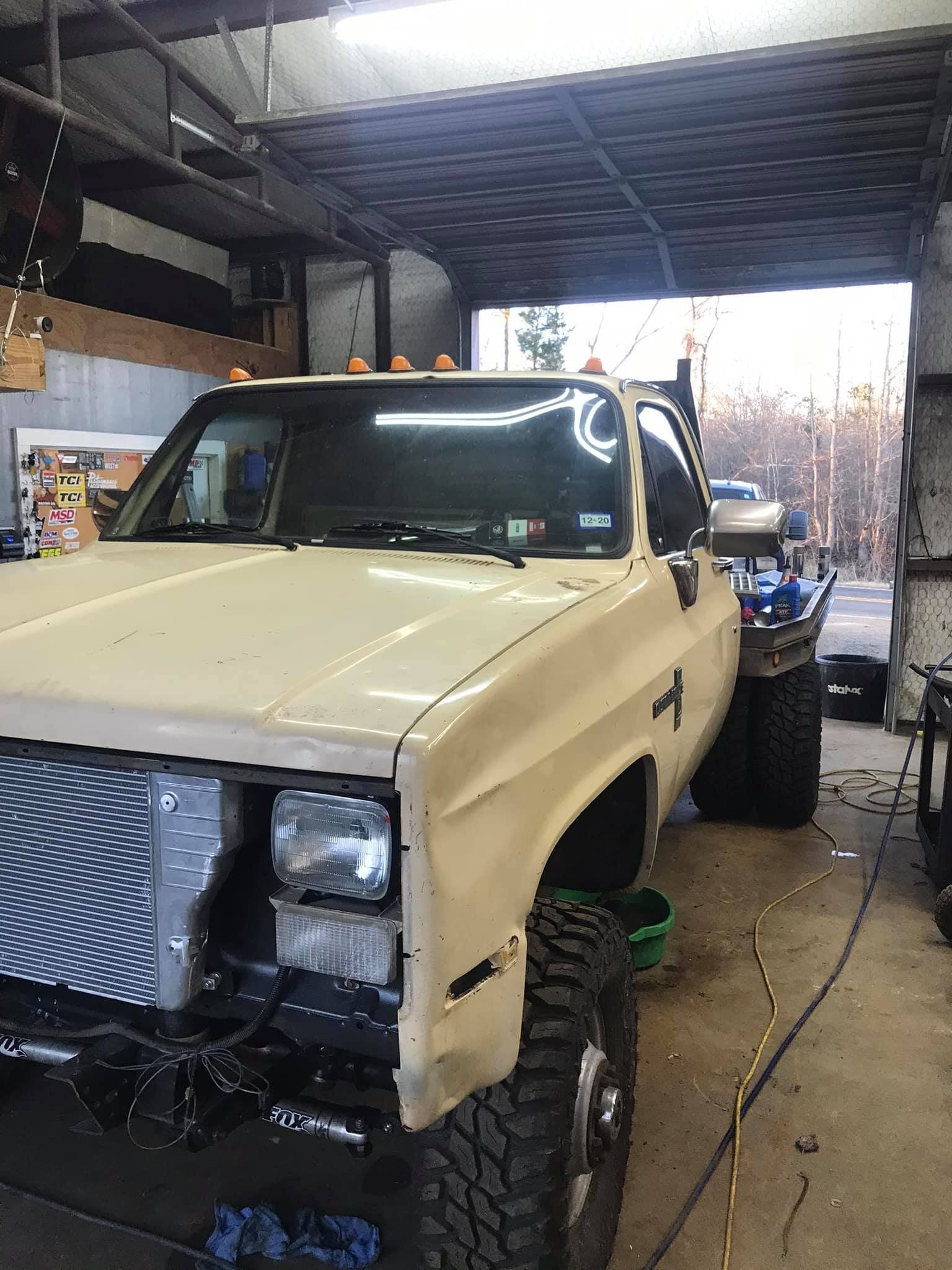 A white truck is parked in a garage.