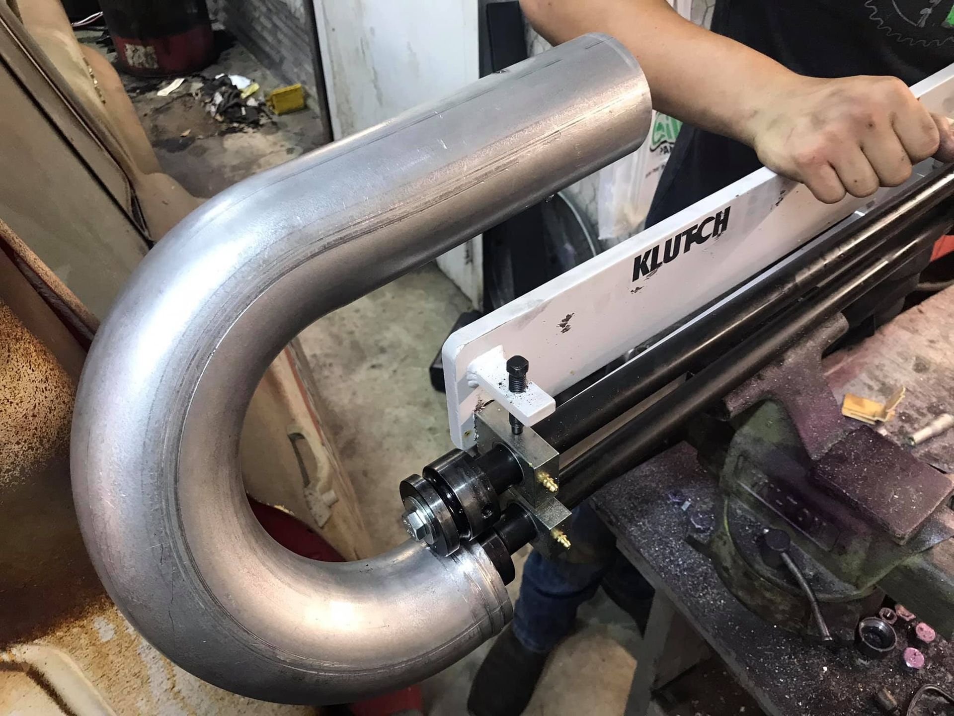 A person is cutting a metal pipe with a machine.