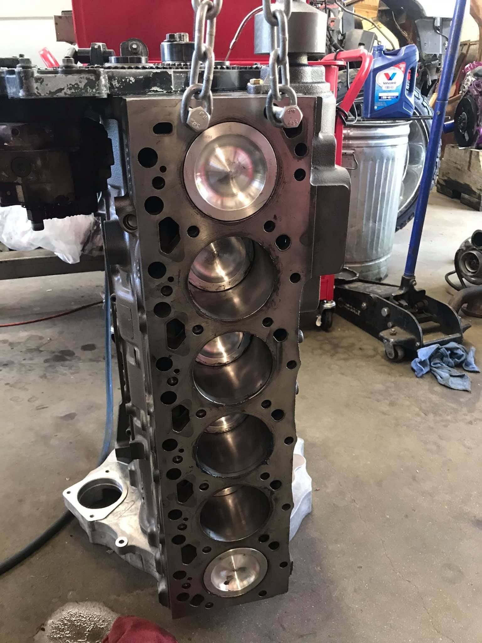 A close up of a cylinder block being worked on in a garage.
