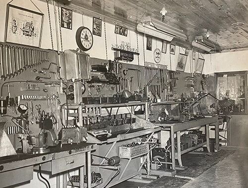 A black and white photo of a workshop filled with lots of tools.