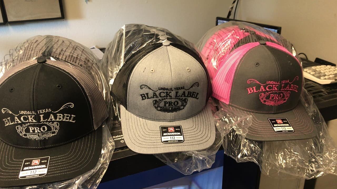 Three black label hats are sitting on a table