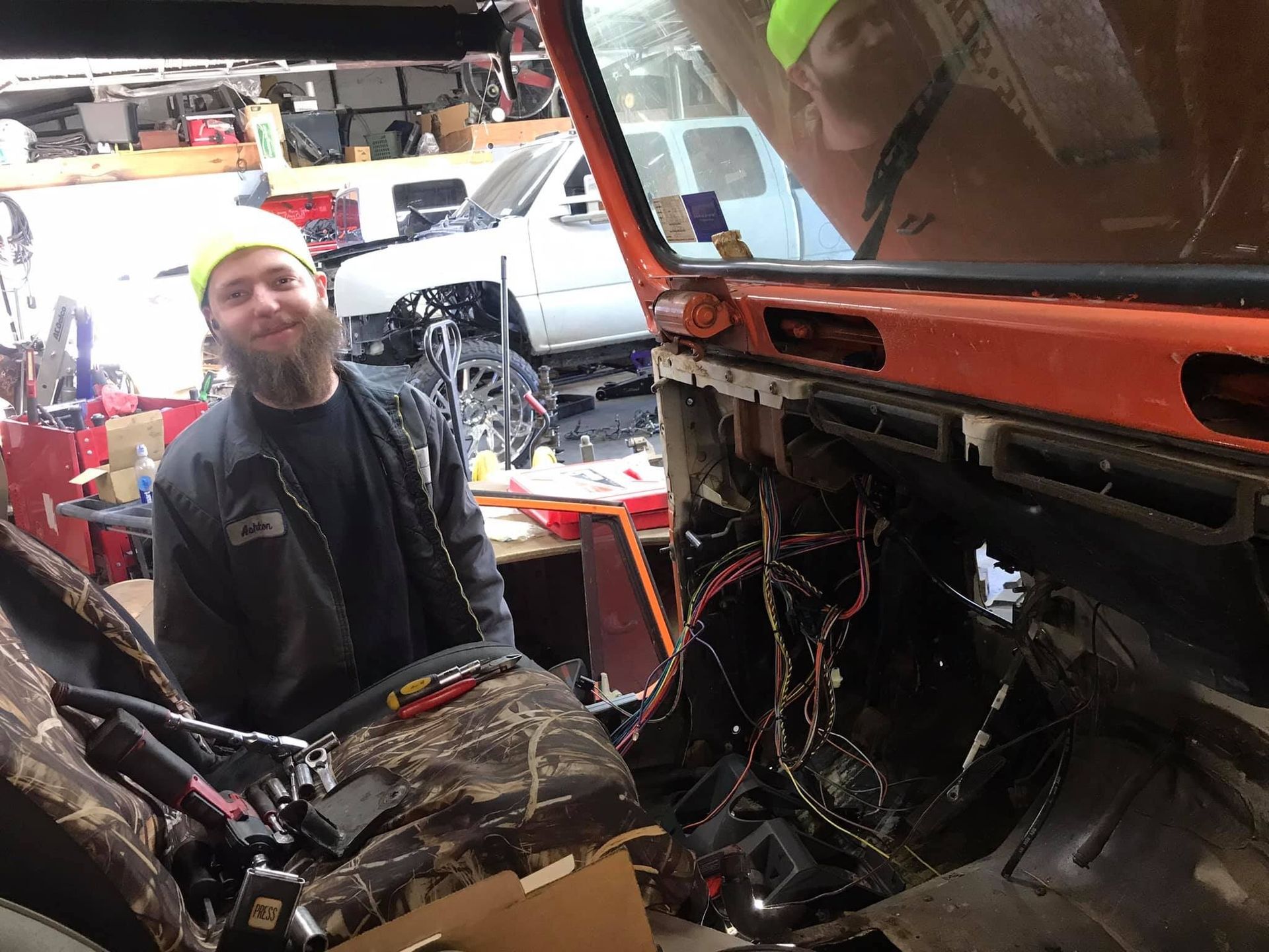 A man with a beard is sitting in the passenger seat of a car.