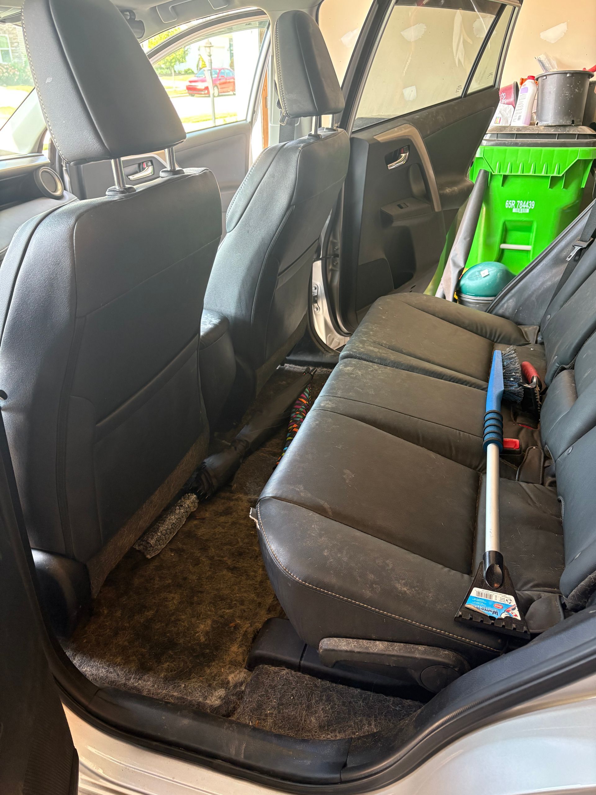 Black Volkswagen wagon from the rear, parked on asphalt, with a concrete wall backdrop. The VW emblem is visible.