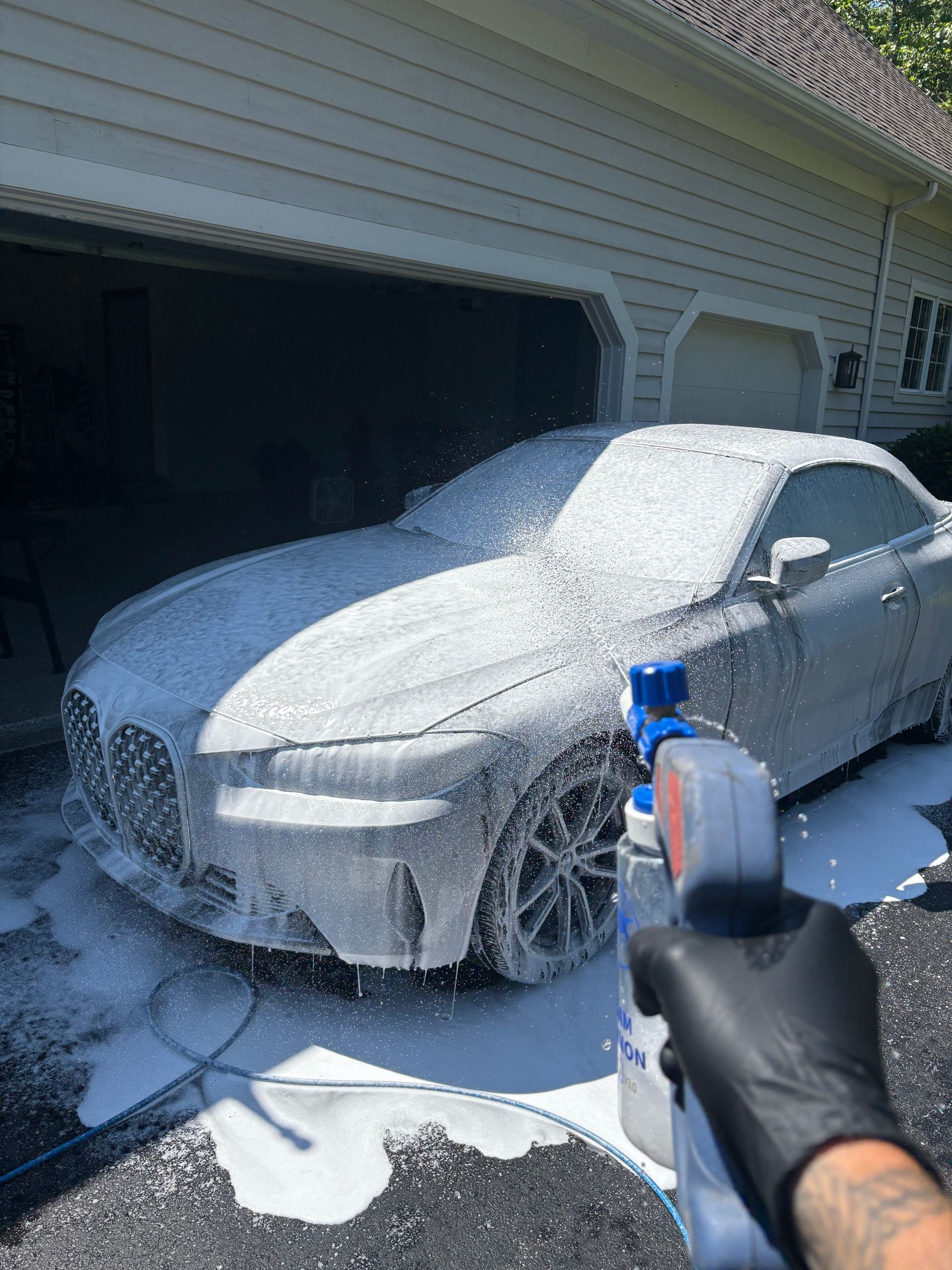 Close-up of a vintage orange and black muscle car, with chrome accents and a black racing stripe, parked outside on a sunny day.