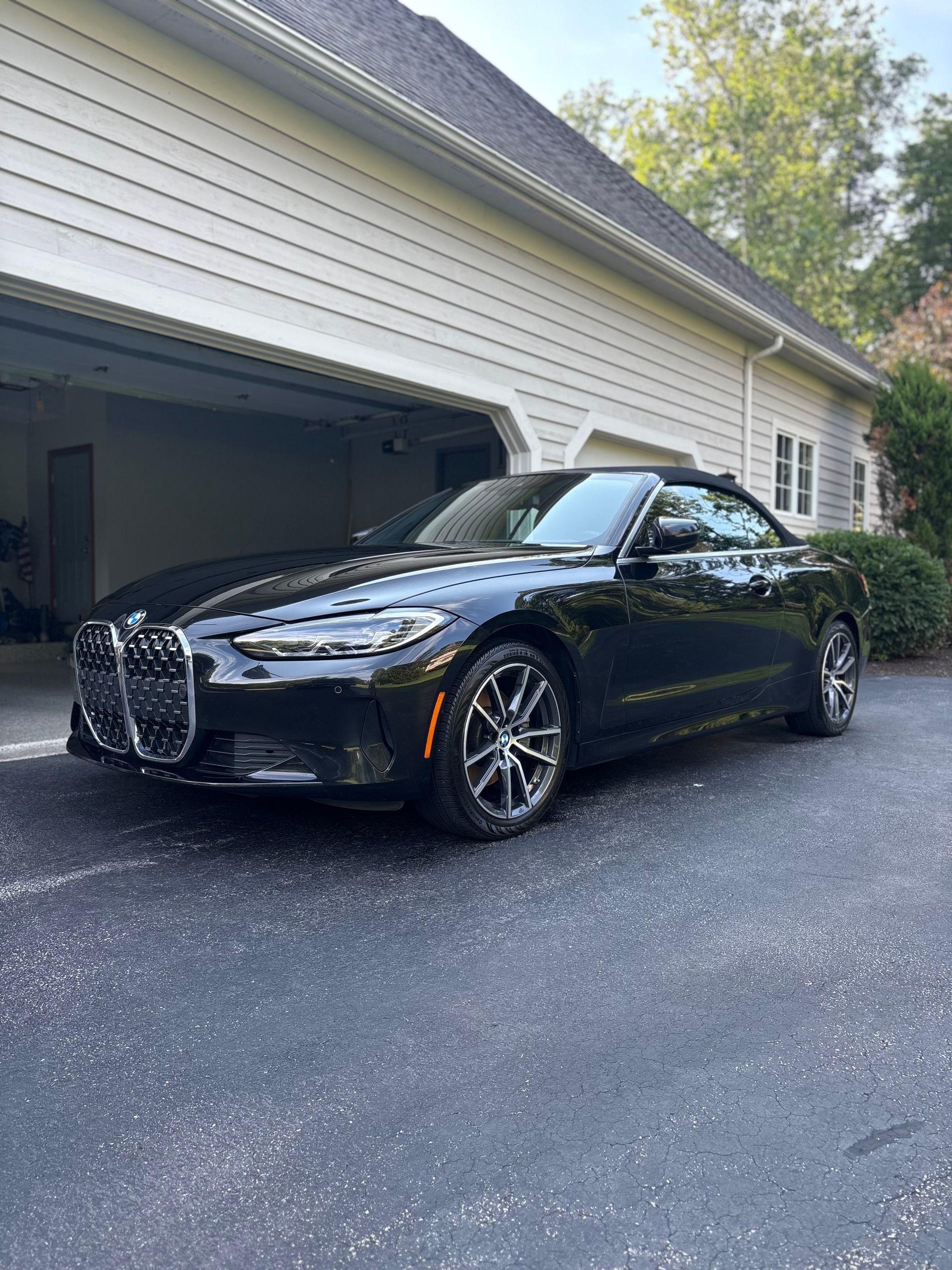 Several luxury black cars parked inside a dimly lit garage, including a Lamborghini, with detailed hoods and rims.