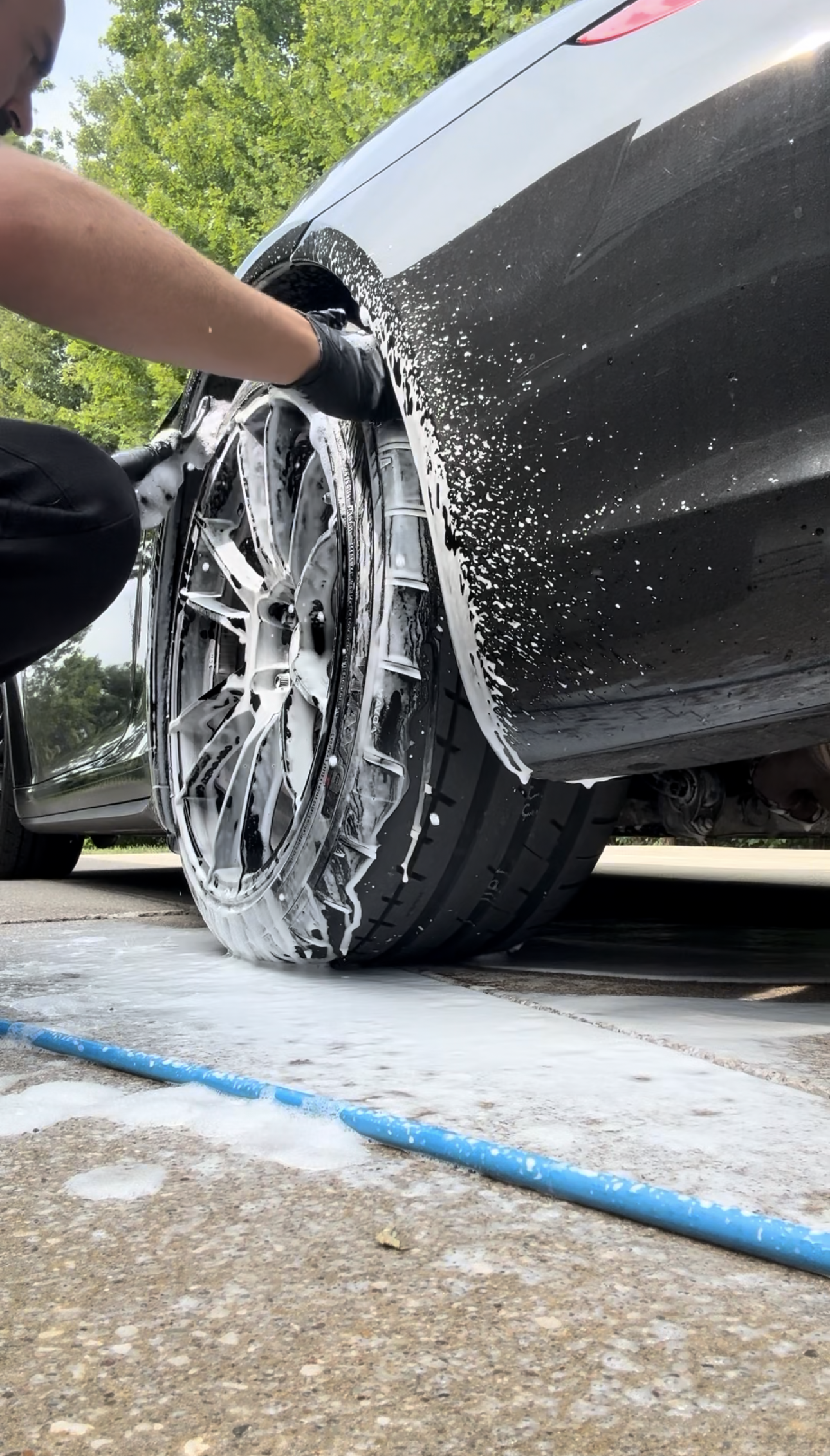 Sleek gray sports car on display, reflecting a showroom setting.