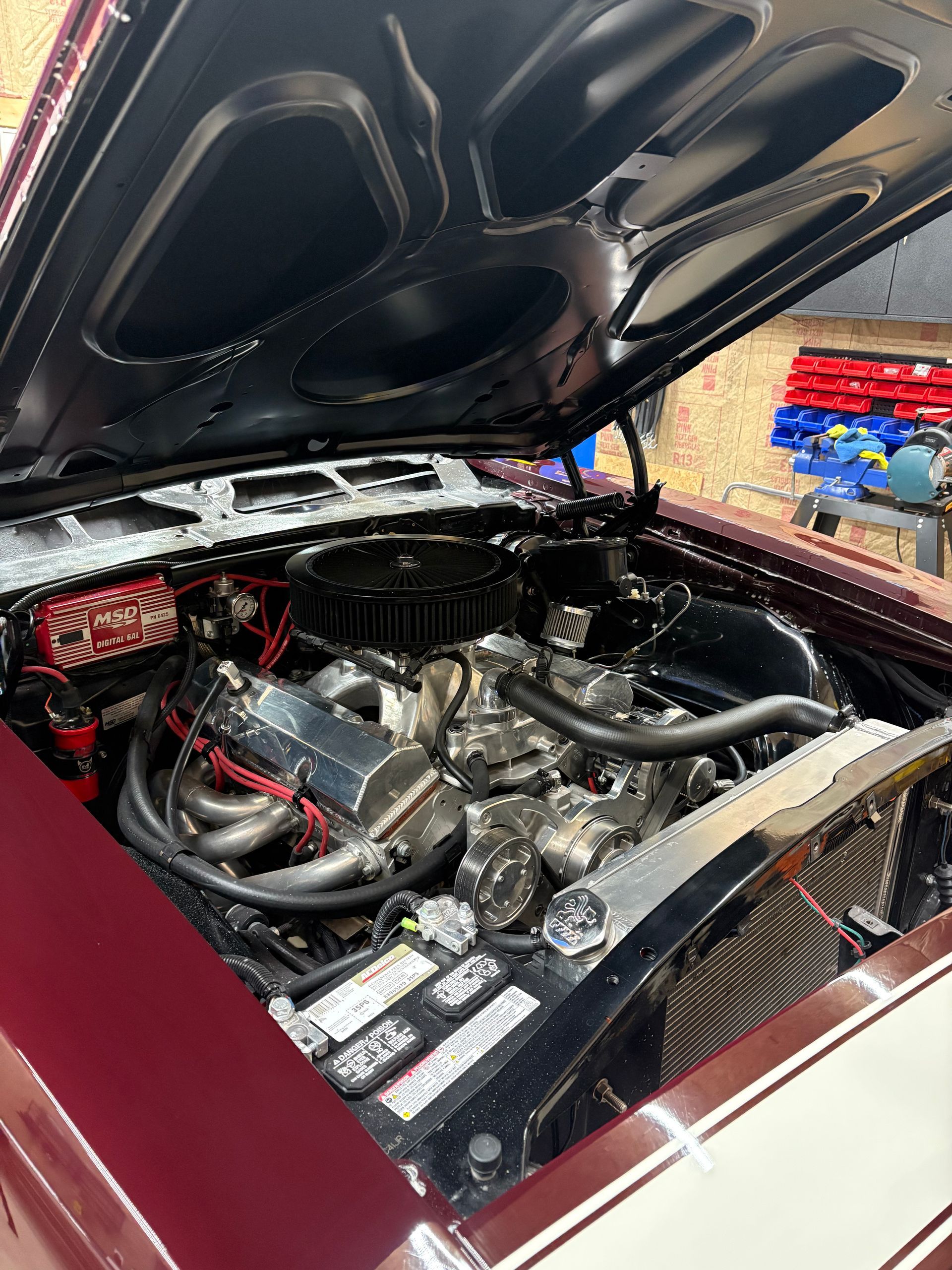 Person using a yellow squeegee to smooth a layer of soapy solution on black surface, likely applying tint film.